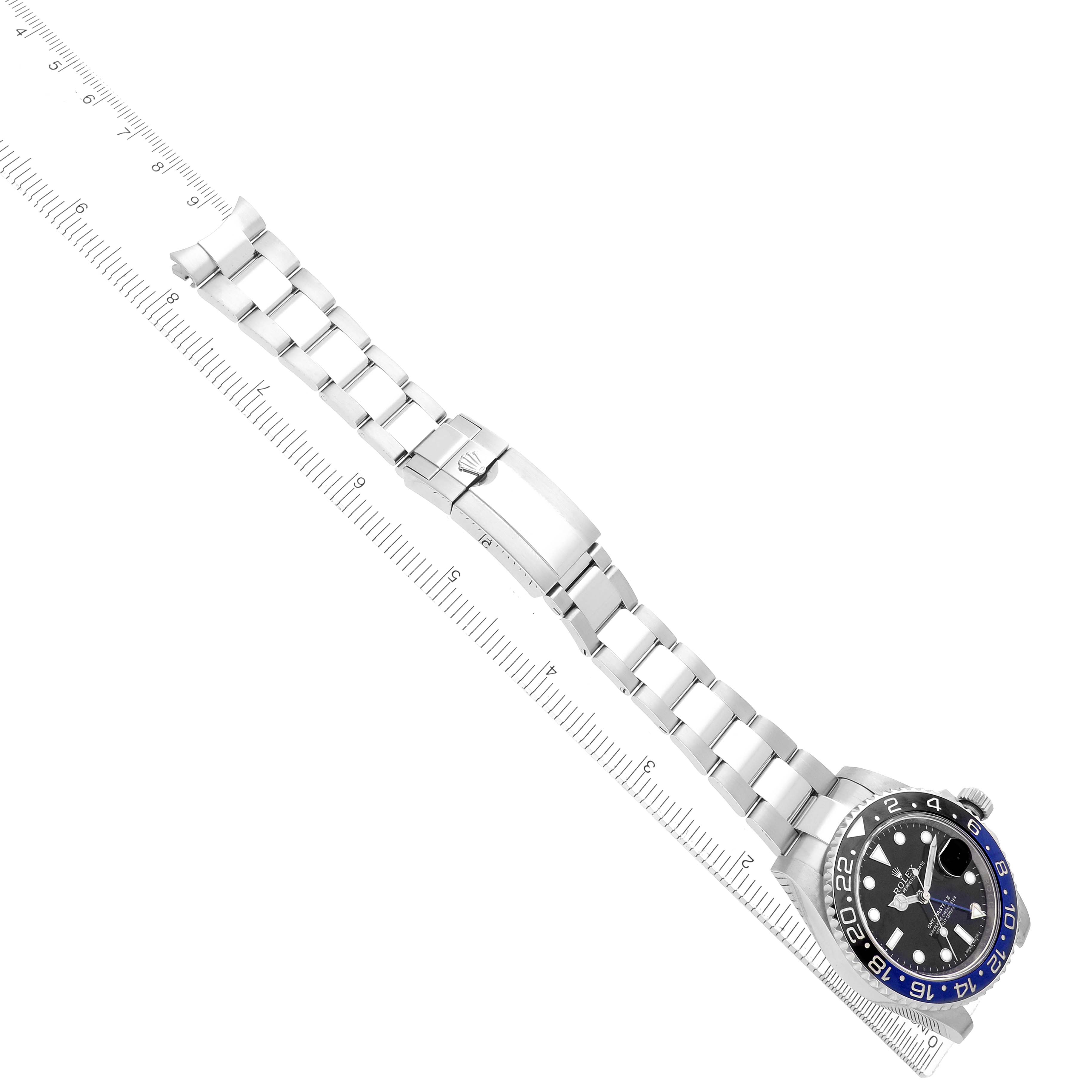The image shows the Rolex GMT-Master 116710 Men
s Stainless Steel Black Dial watch laid flat with its bracelet extended, alongside a ruler for size reference.