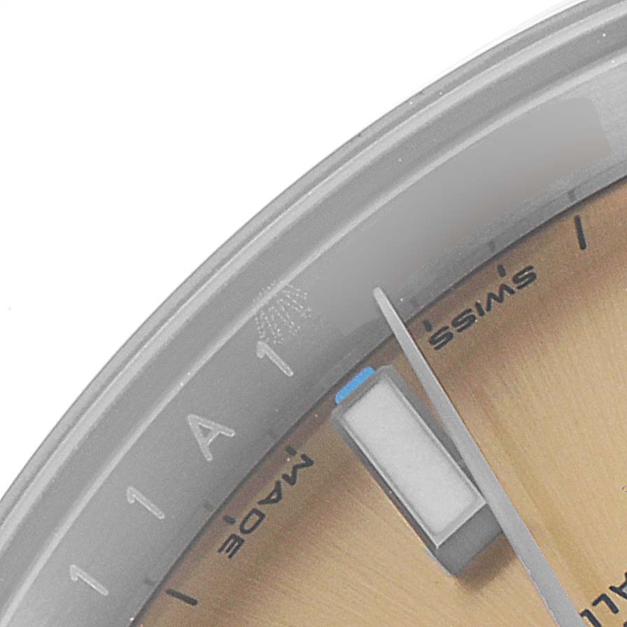 The image shows a close-up of the dial and bezel of a Rolex Oyster Perpetual 114200 Men's Stainless Steel Champagne Dial 114200 Men's Stainless Steel Champagne Dial watch, highlighting the second hand and part of "SWISS MADE" text.