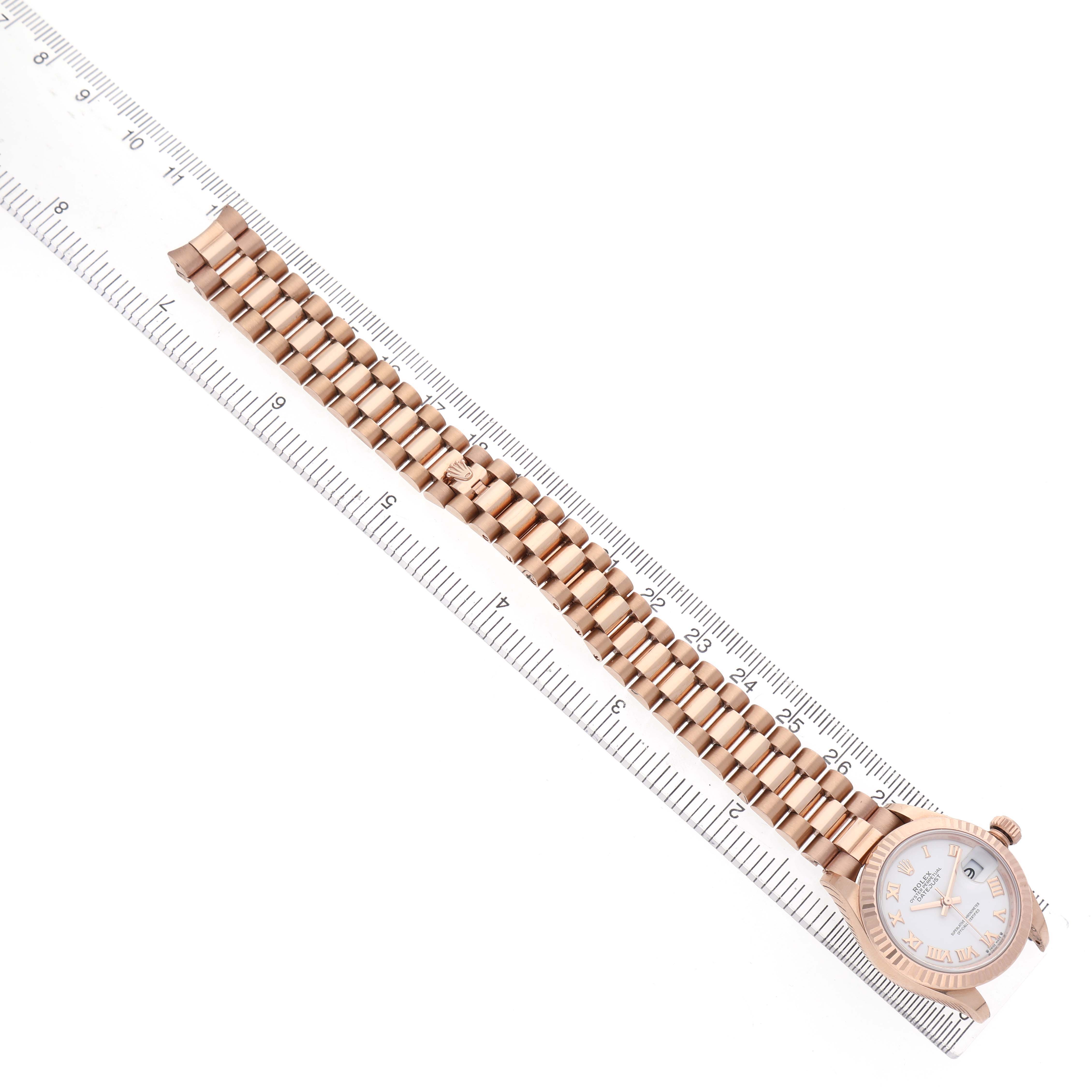 The Rolex President 279175 Women's Rose Gold White Dial model watch is displayed flat from above, showing the full bracelet and dial alongside a ruler for scale.