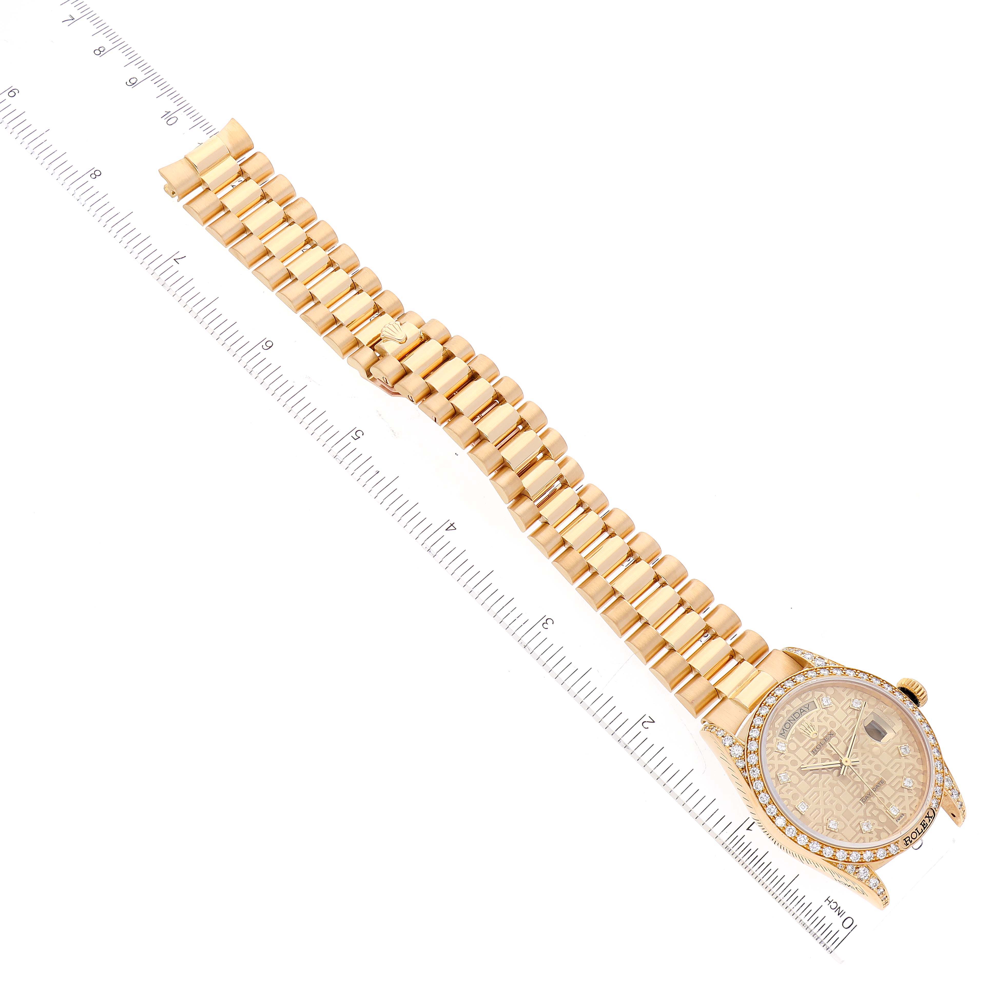 The image shows a top-down view of a Rolex President 18138 Men
s Yellow Gold Champagne Dial 18138 Men
s Yellow Gold Champagne Dial model watch, including its face, bezel, and bracelet next to a ruler for scale.