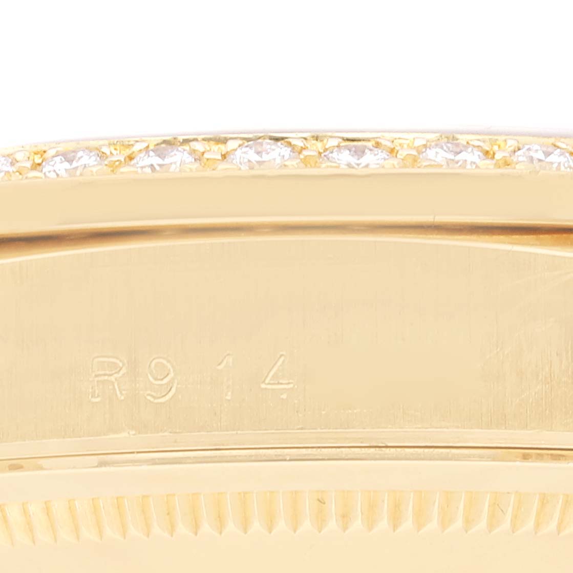 This image shows a close-up of the side of a Rolex President 18348 Men's Yellow Gold Champagne Dial 18348 Men's Yellow Gold Champagne Dial model watch, highlighting the gold case, diamond bezel, and engraved "R914".