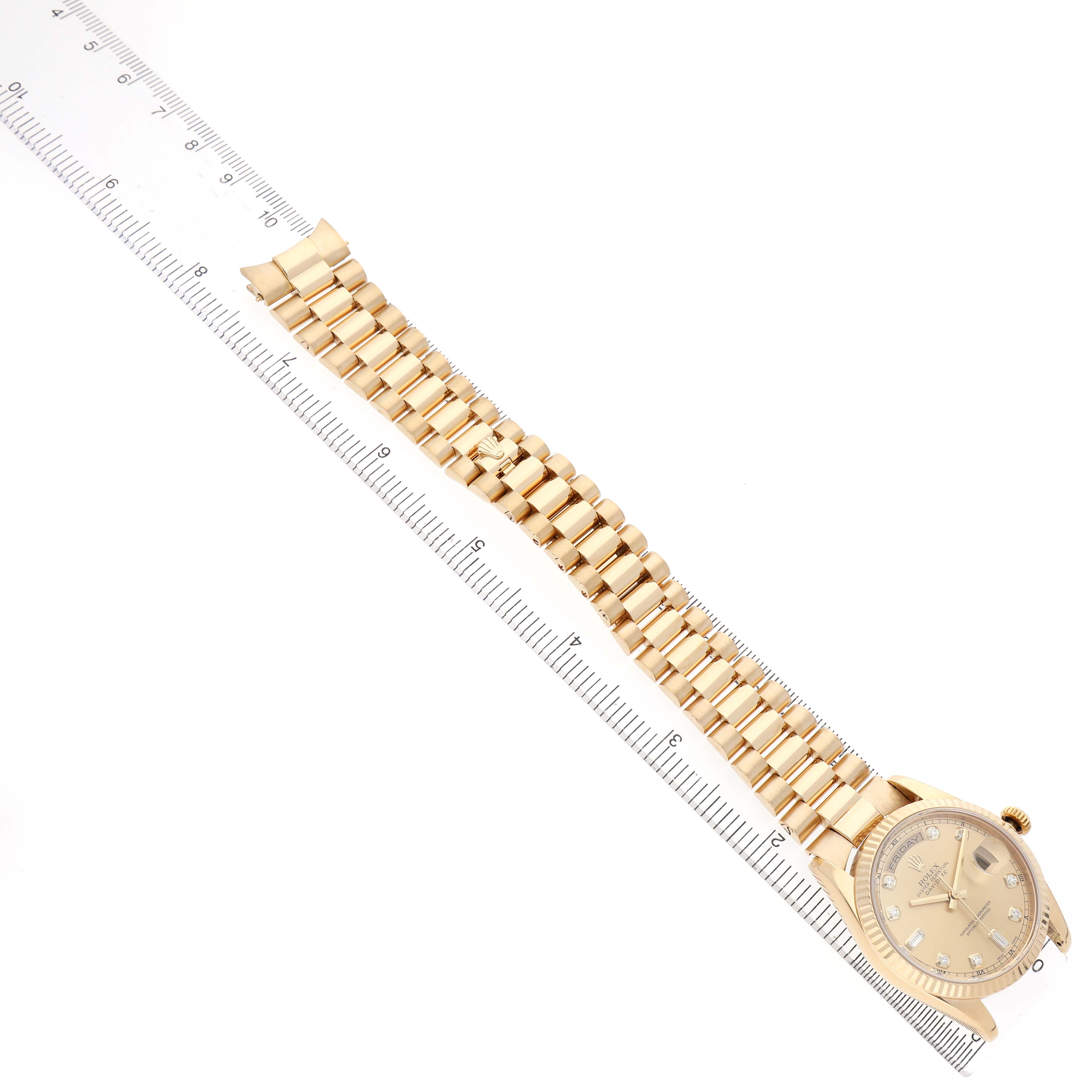 The Rolex President 118238 Men's Yellow Gold Champagne Dial watch is shown from an angled top view, highlighting the face and full bracelet alongside a ruler.