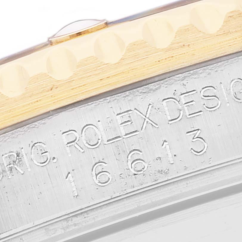 The image shows a close-up of the side of the Rolex Submariner 16613 Men's Steel and Gold (two tone) Black Dial 16613 Men's Steel and Gold (two tone) Black Dial case with model and design engravings.