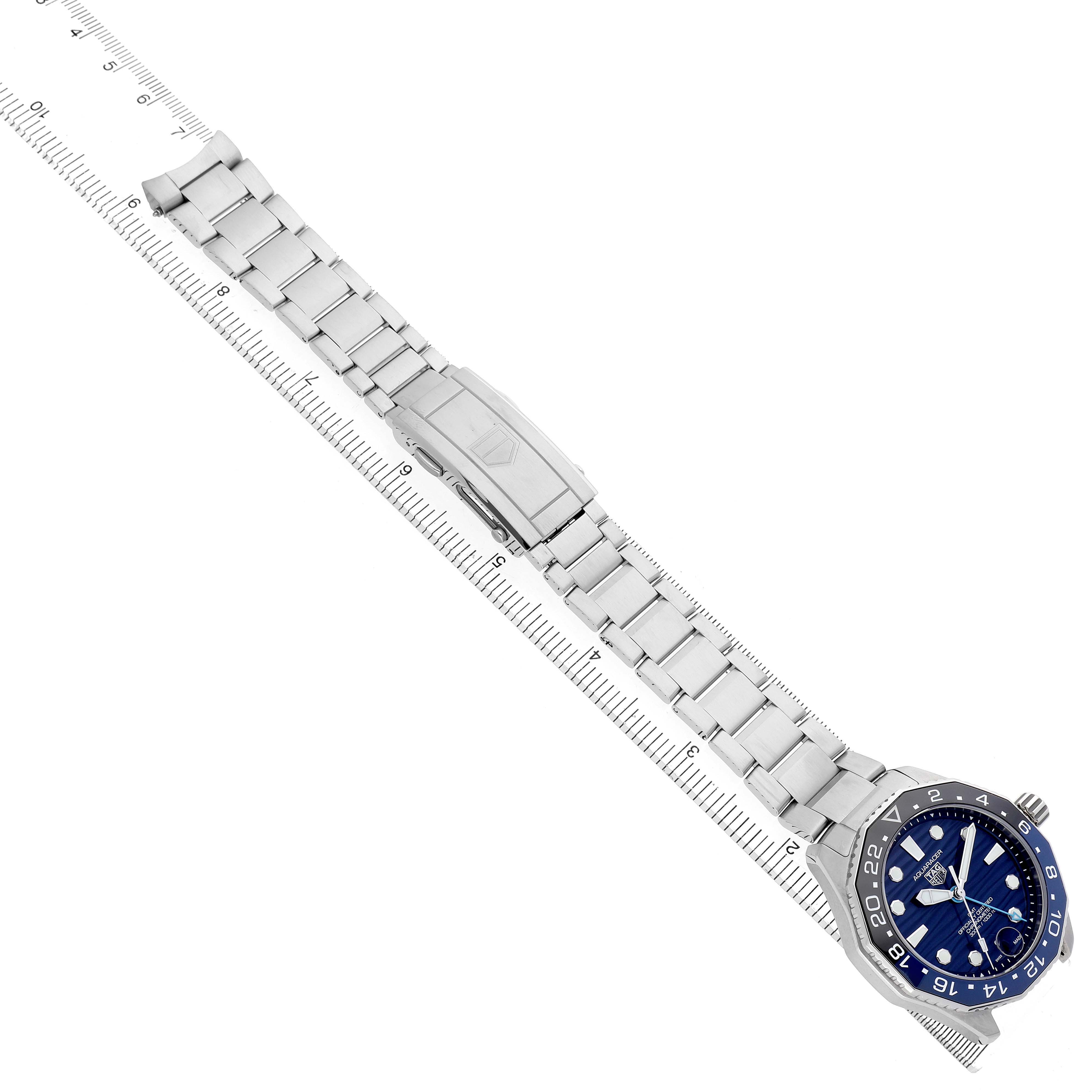 The TAG Heuer Aquaracer watch is shown at an angle highlighting the full bracelet and clasp, with the face and bezel visible.