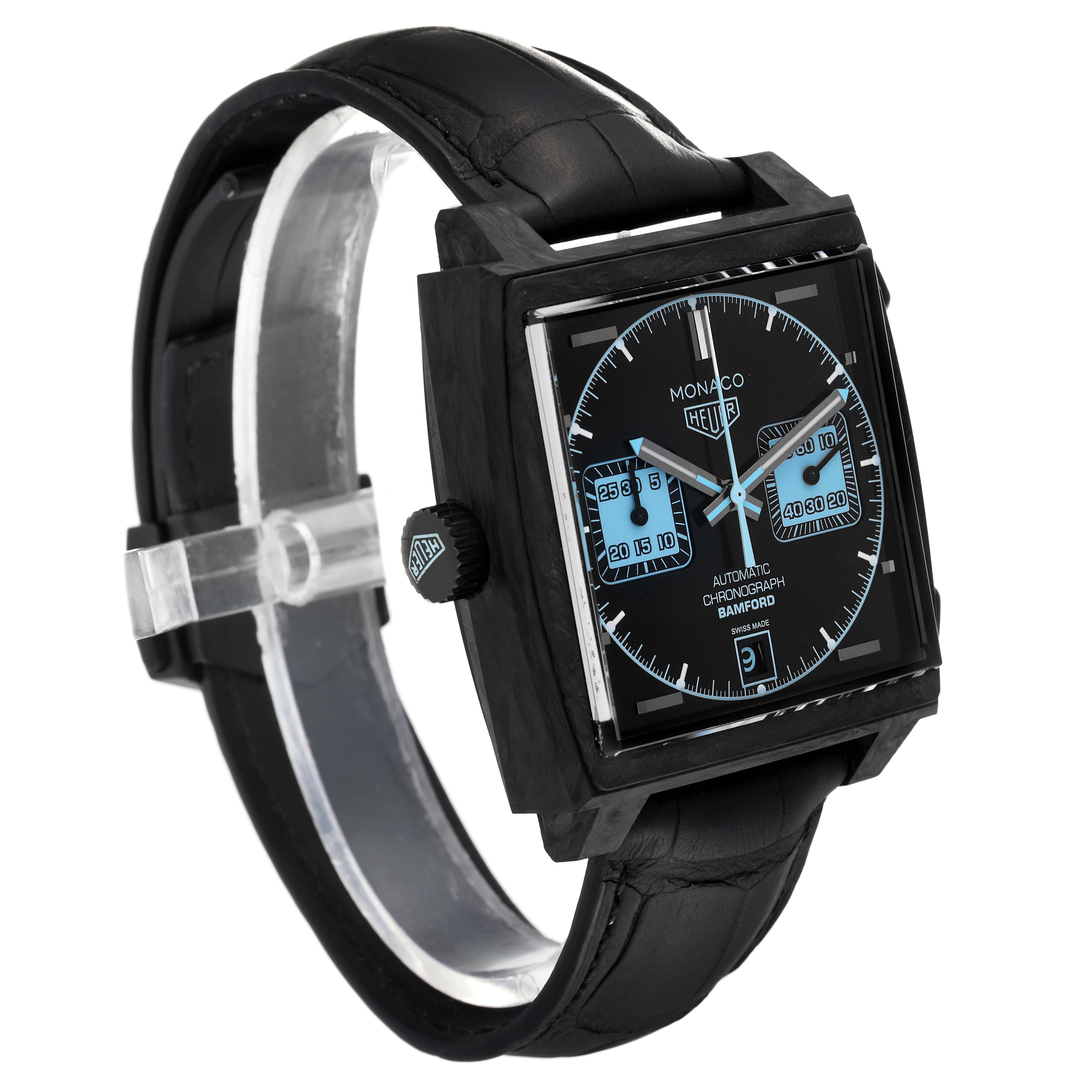 The image shows a Tag Heuer Monaco model watch from a slightly angled side view, highlighting the black case, dial, and leather strap.