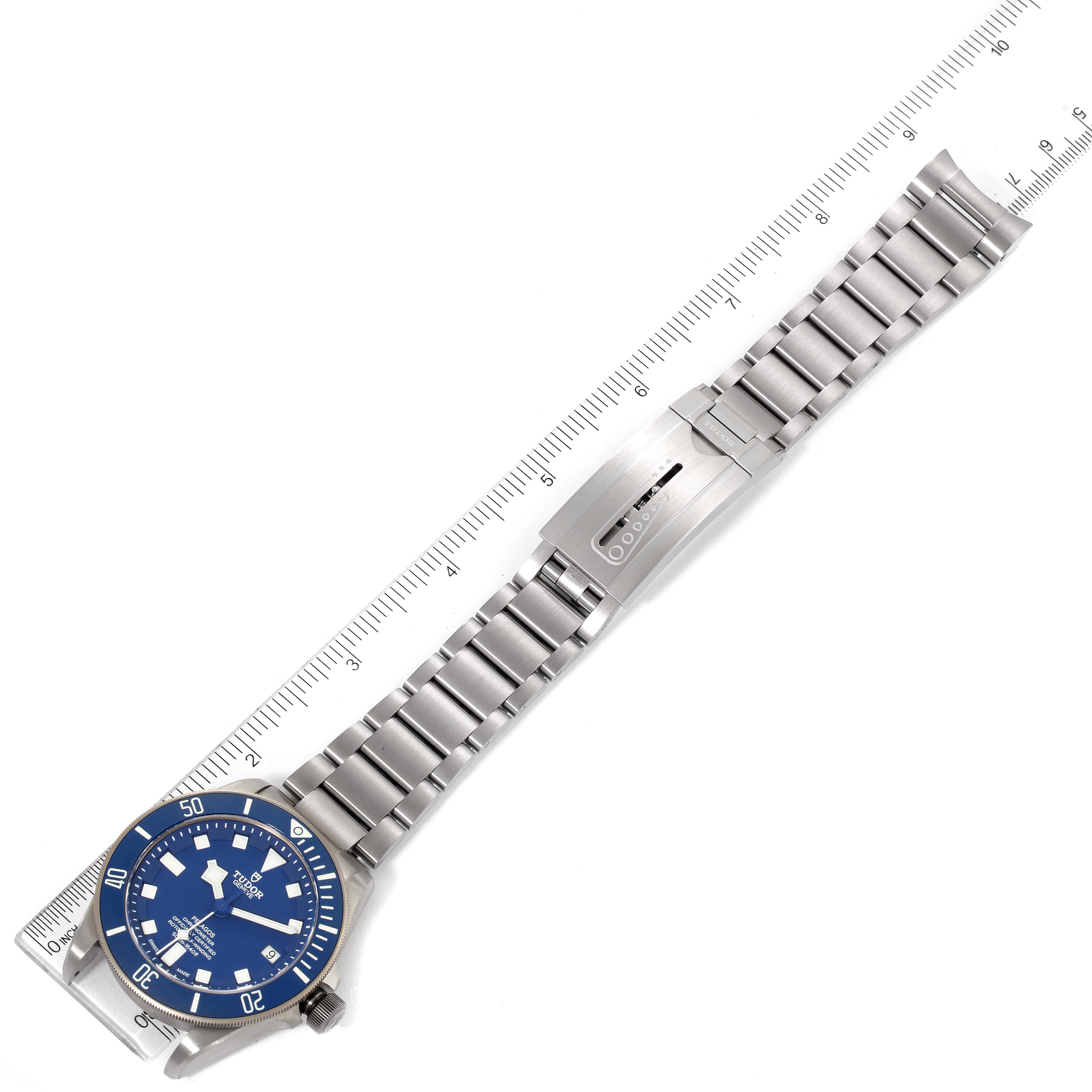 This image shows a Tudor Pelagos 25600TV Men
s Titanium Blue Dial 25600TV Men
s Titanium Blue Dial watch placed flat, displaying its blue dial, metal bracelet, and clasp with a ruler for scale.