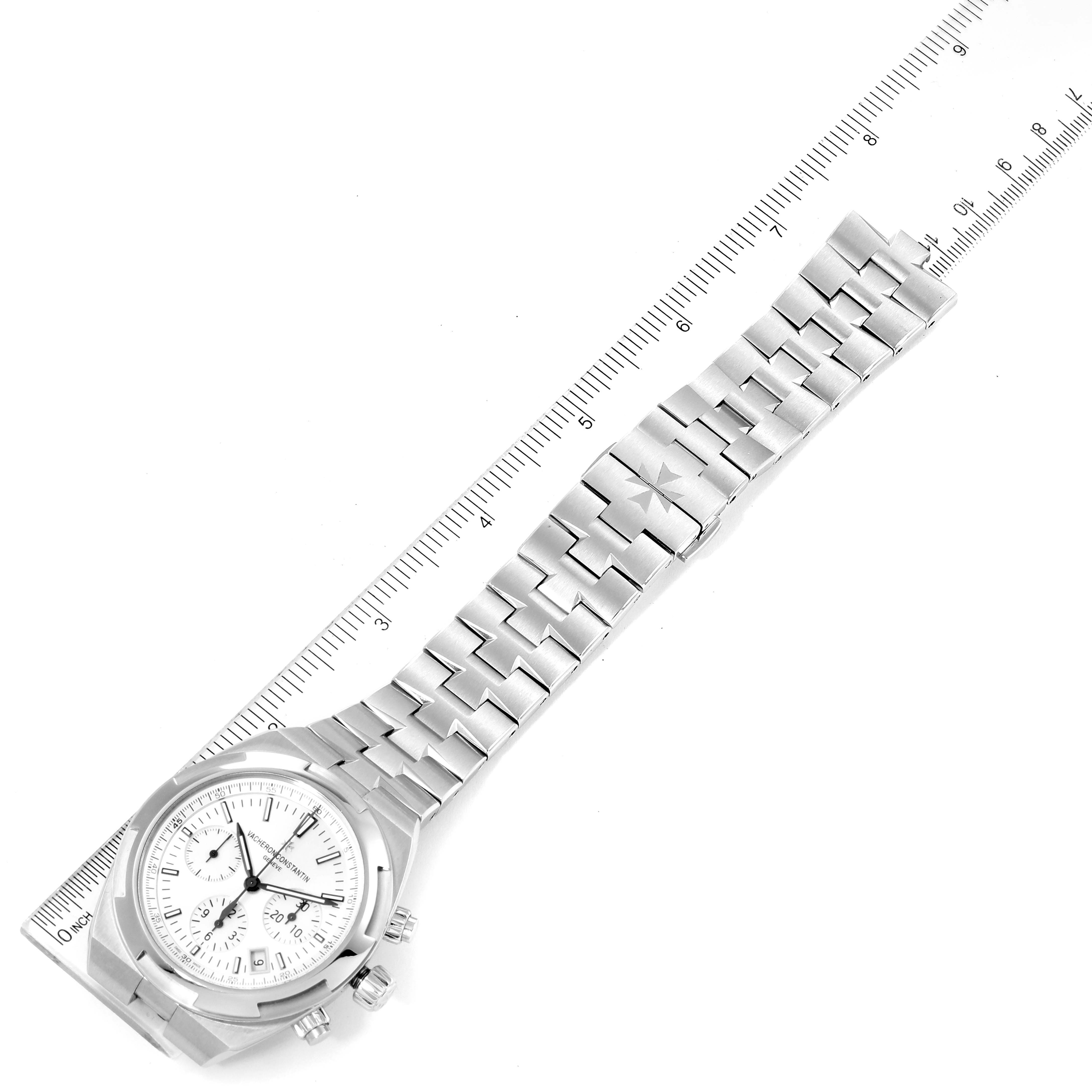 The Vacheron Constantin Overseas 5500V/110A Men's Stainless Steel Silver Dial 5500V/110A Men's Stainless Steel Silver Dial watch is shown from the top angle, displaying its face, bezel, and bracelet next to a ruler.