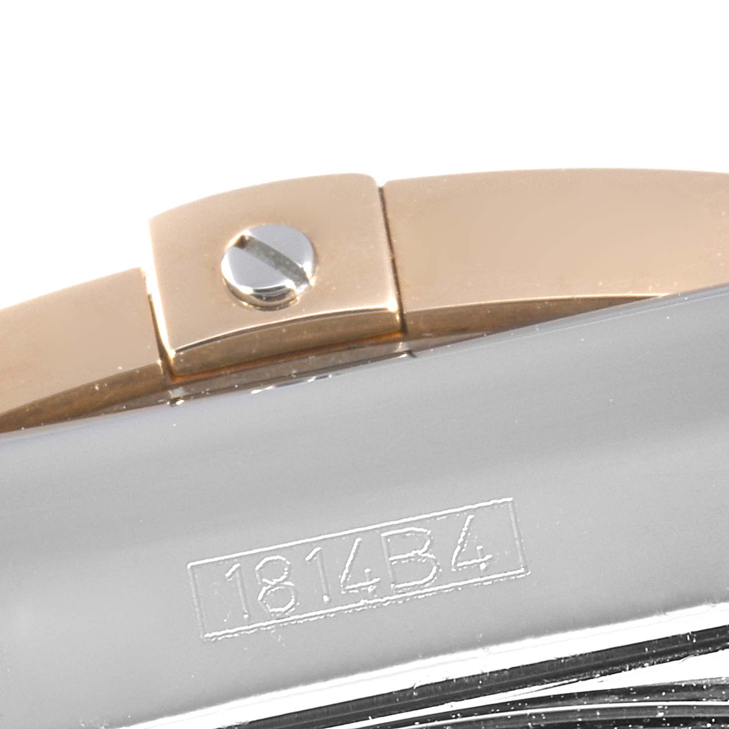 The image shows a close-up of part of a Breitling Chronomat CB011012 Men's Steel and Gold (two tone) Black Dial CB011012 Men's Steel and Gold (two tone) Black Dial watch, highlighting a segment of the band and a screw.