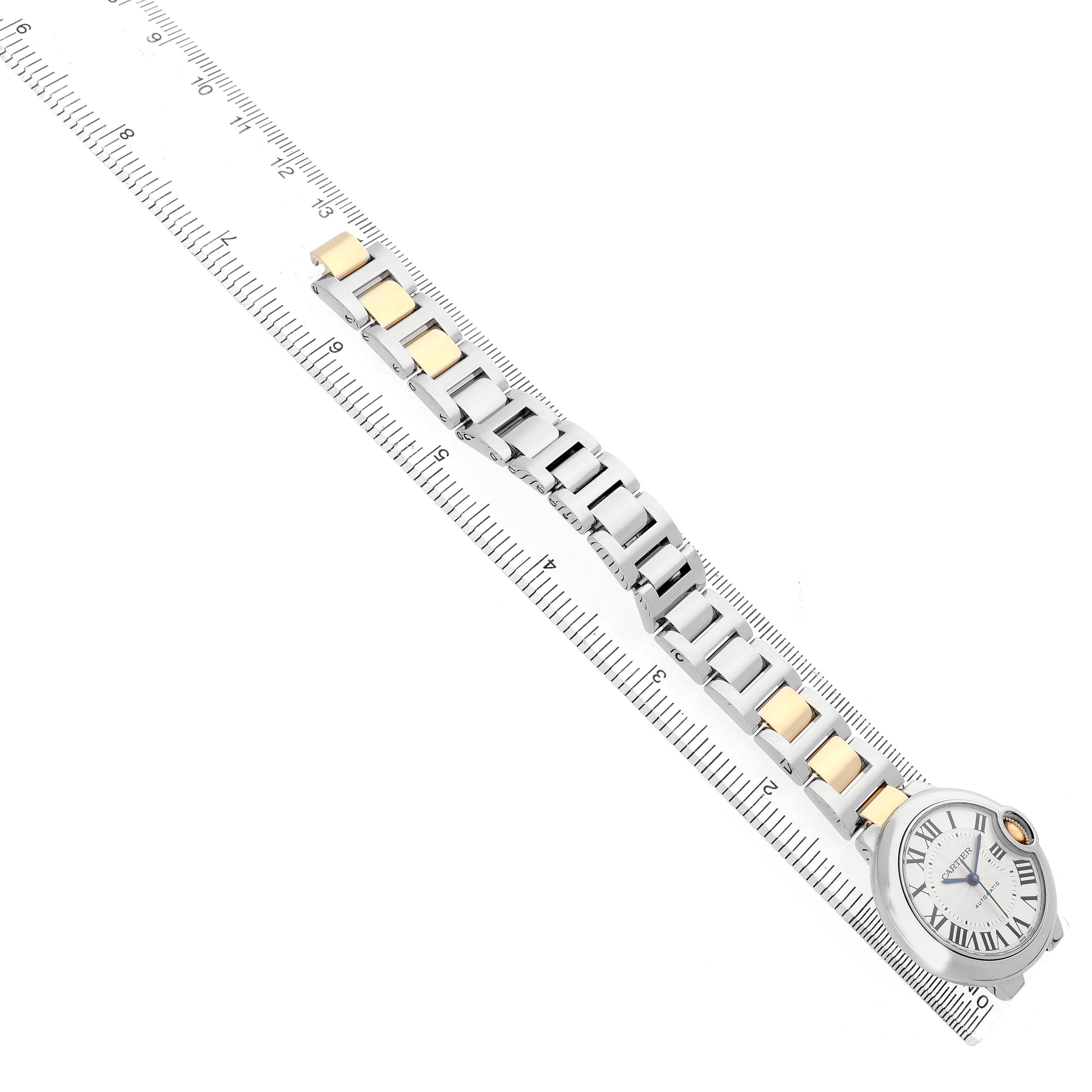 The Cartier Ballon Bleu W2BB0002 Women's Stainless Steel Silver Dial watch is shown at an angle displaying the face and bracelet alongside a measuring ruler.