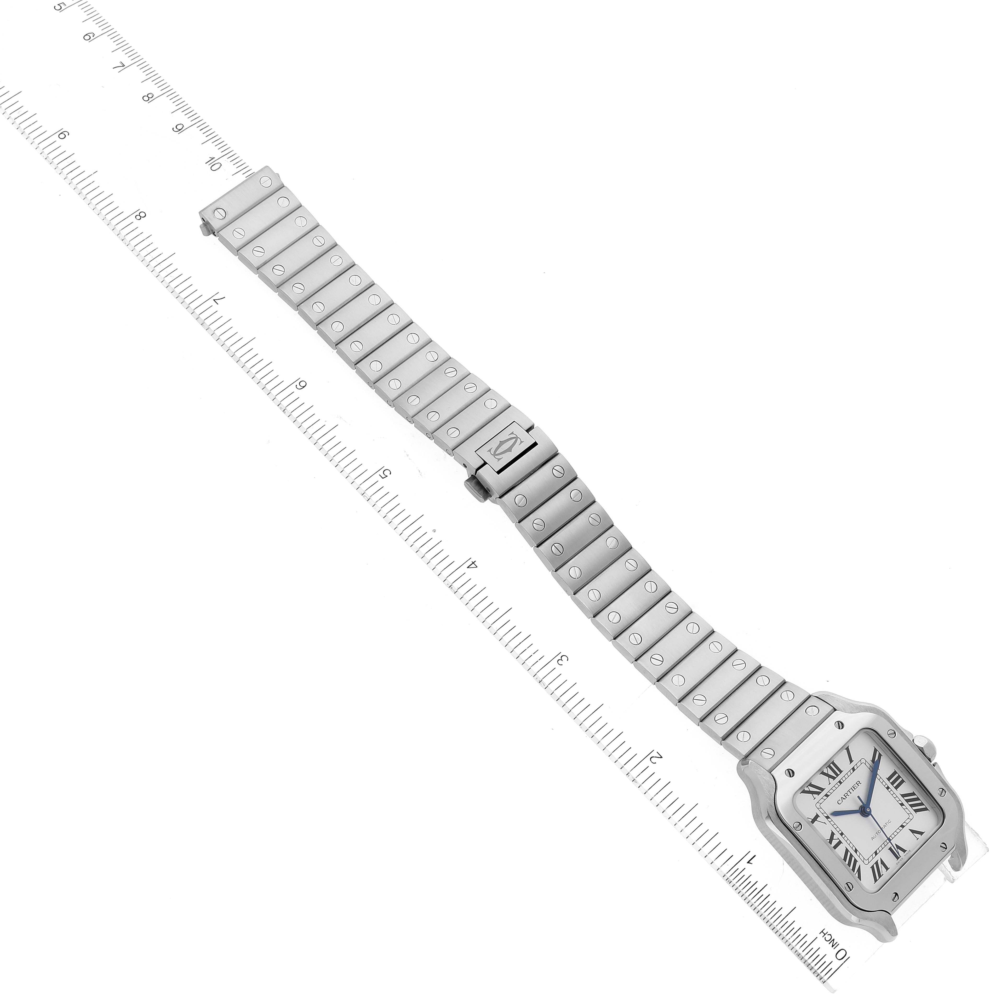 The image shows a top-down view of a Santos model Cartier watch, highlighting its face, bezel, and metallic bracelet.