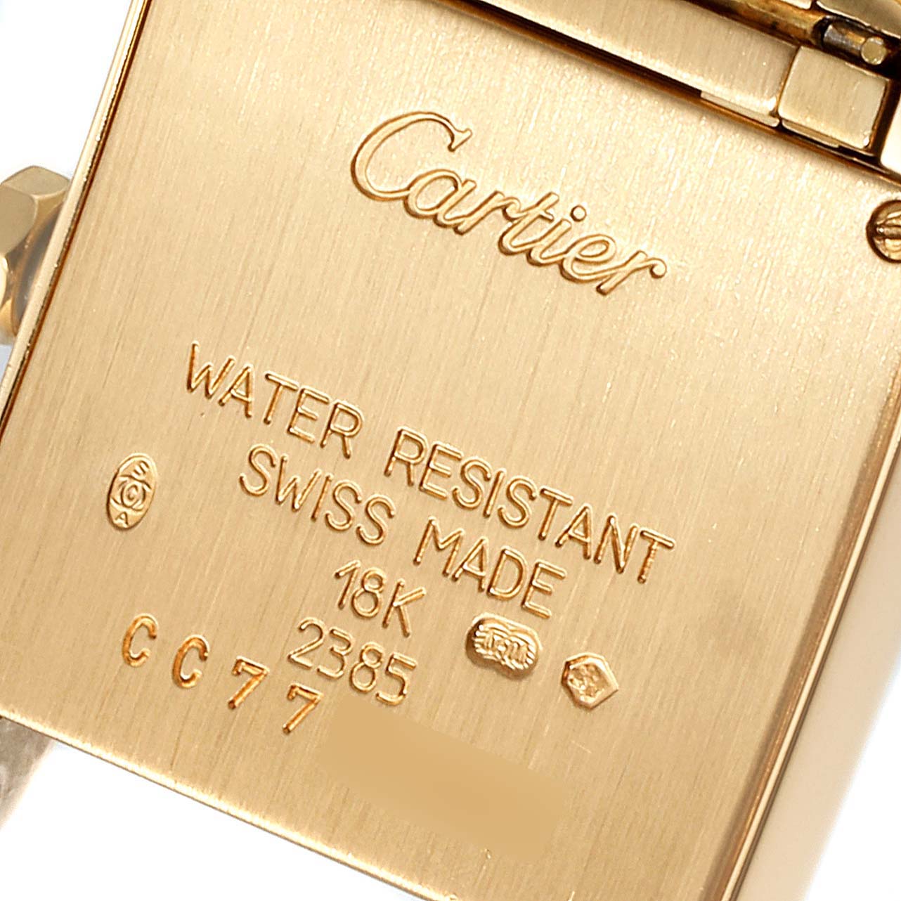 The image shows the back side of a Cartier Tank Française watch, highlighting engravings and hallmark details.