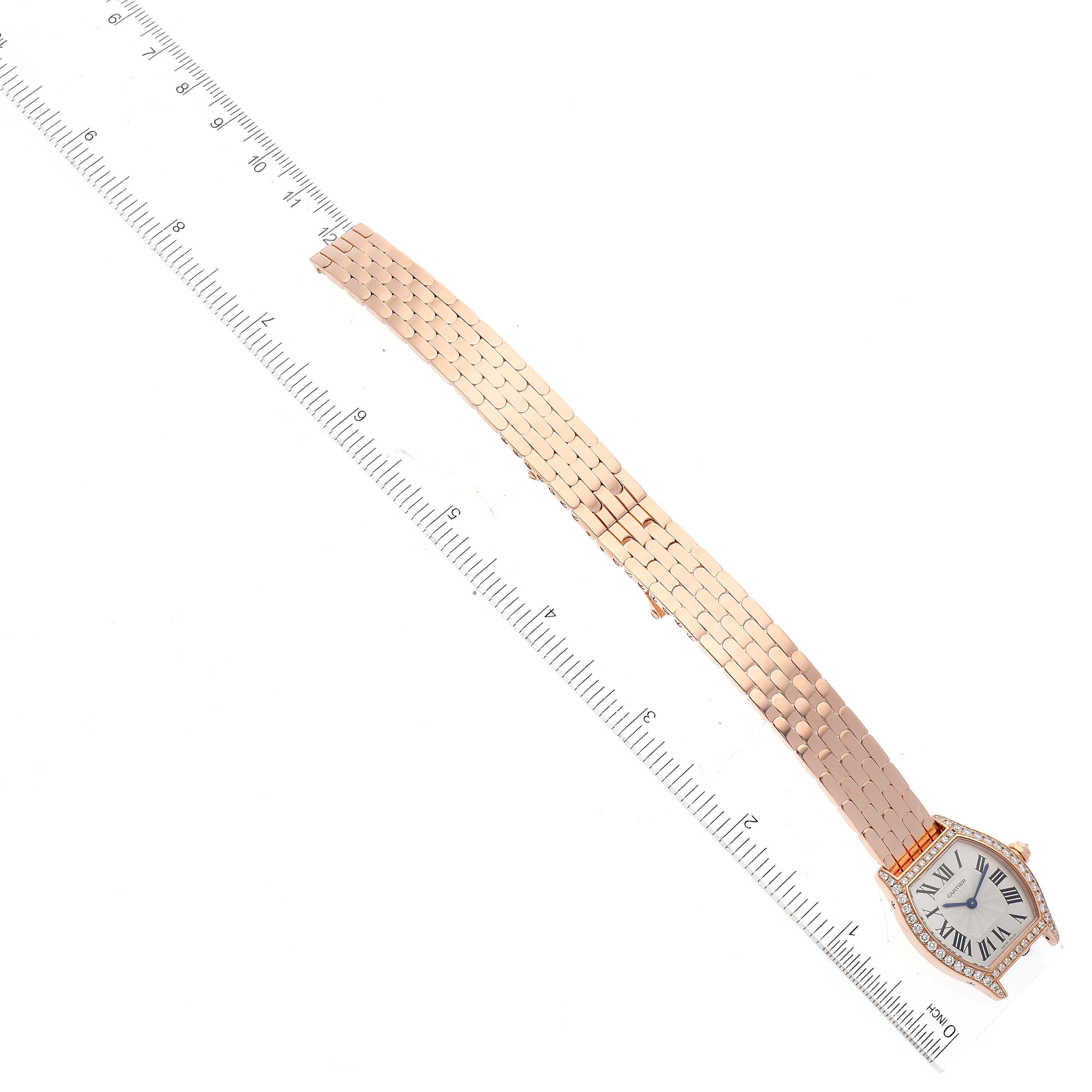This image shows a Cartier Tortue WA501010 Women
s Rose Gold Silver Dial WA501010 Women
s Rose Gold Silver Dial watch with a rose gold bracelet and white dial, angled diagonally next to a ruler for scale.