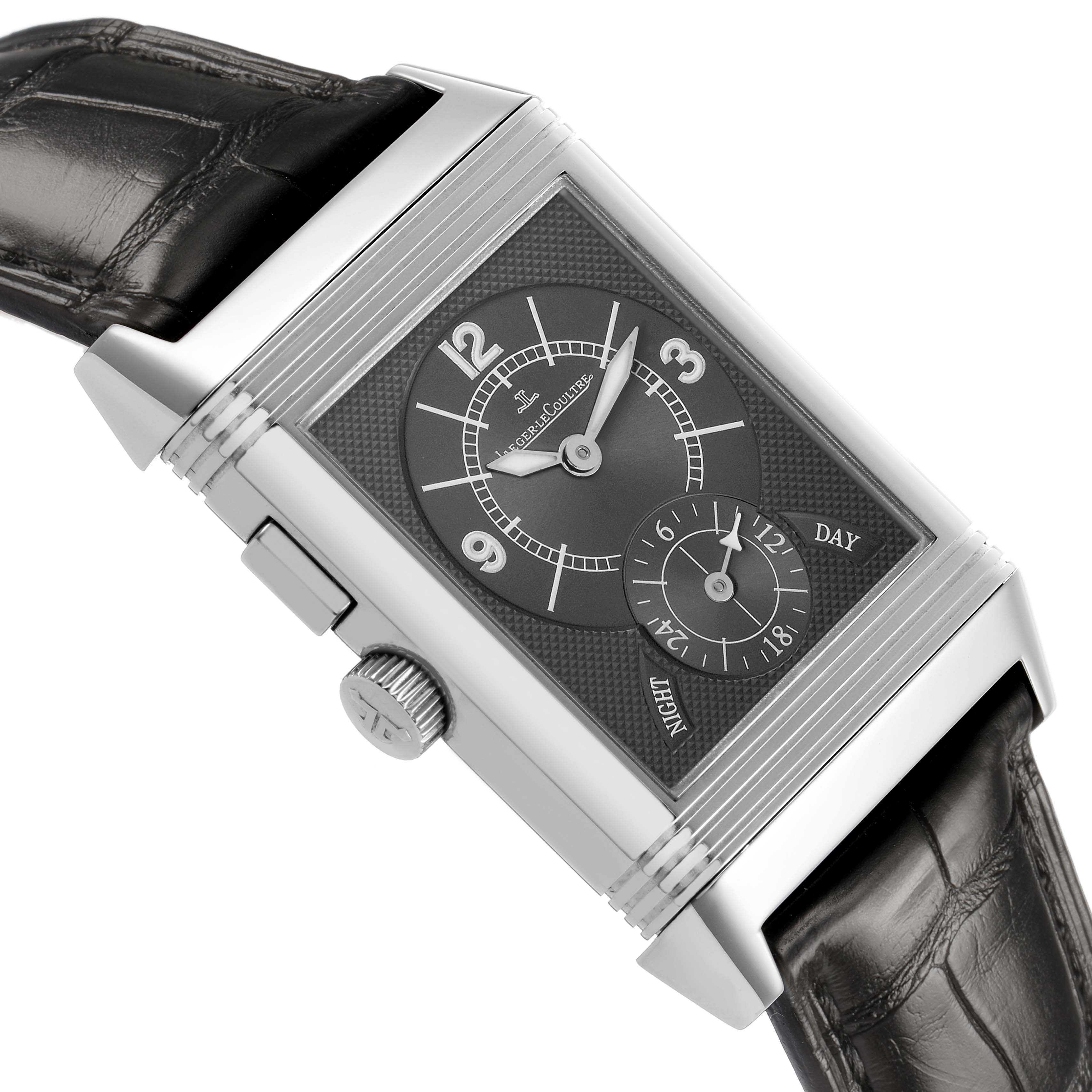 The image shows a Jaeger-LeCoultre Reverso watch at a tilted angle, highlighting its face, crown, and leather strap.
