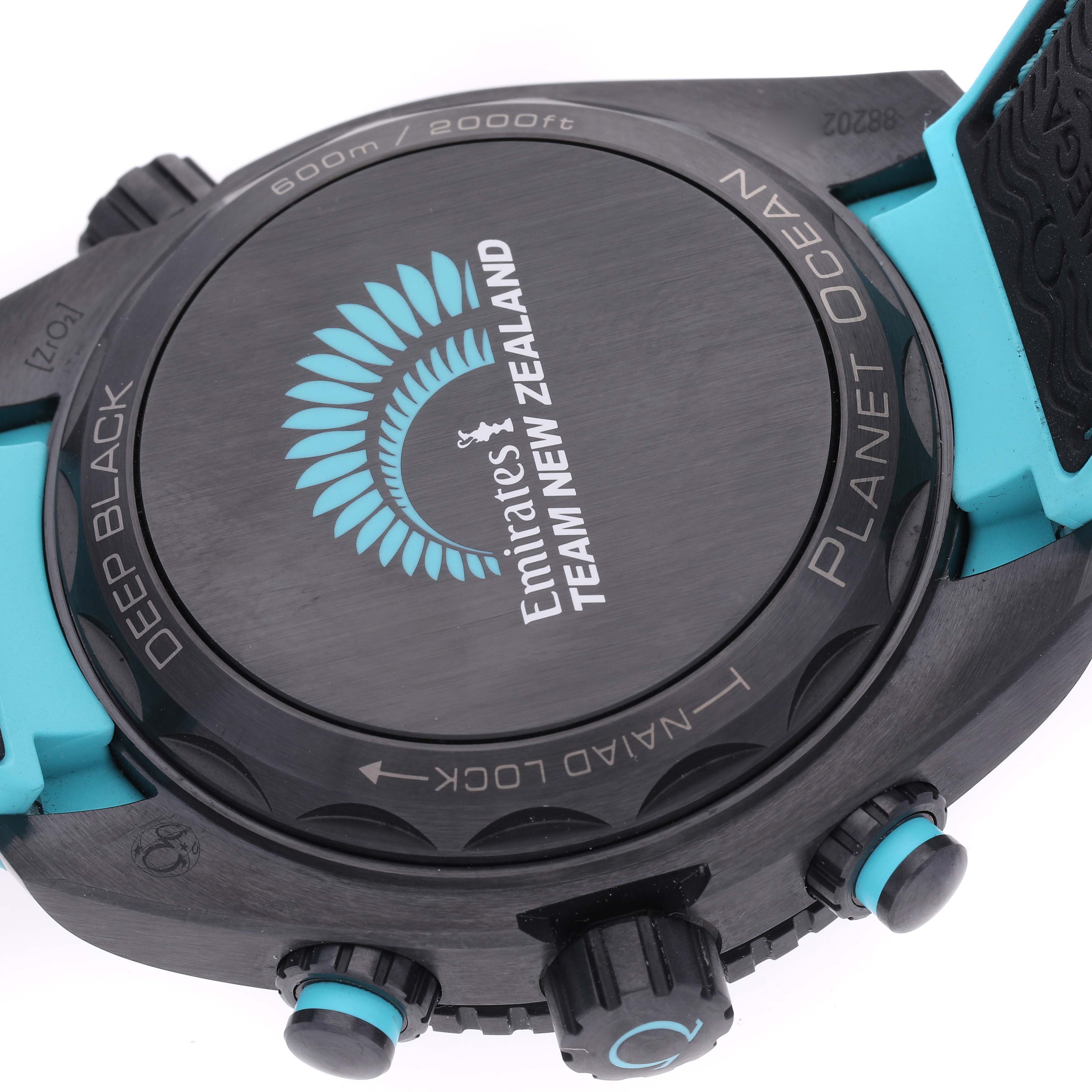 This image shows the back case and crown of the Omega Planet Ocean 215.92.46.51.01.003 Men's Ceramic Black Dial 215.92.46.51.01.003 Men's Ceramic Black Dial watch, highlighting the "Team New Zealand" engraving.
