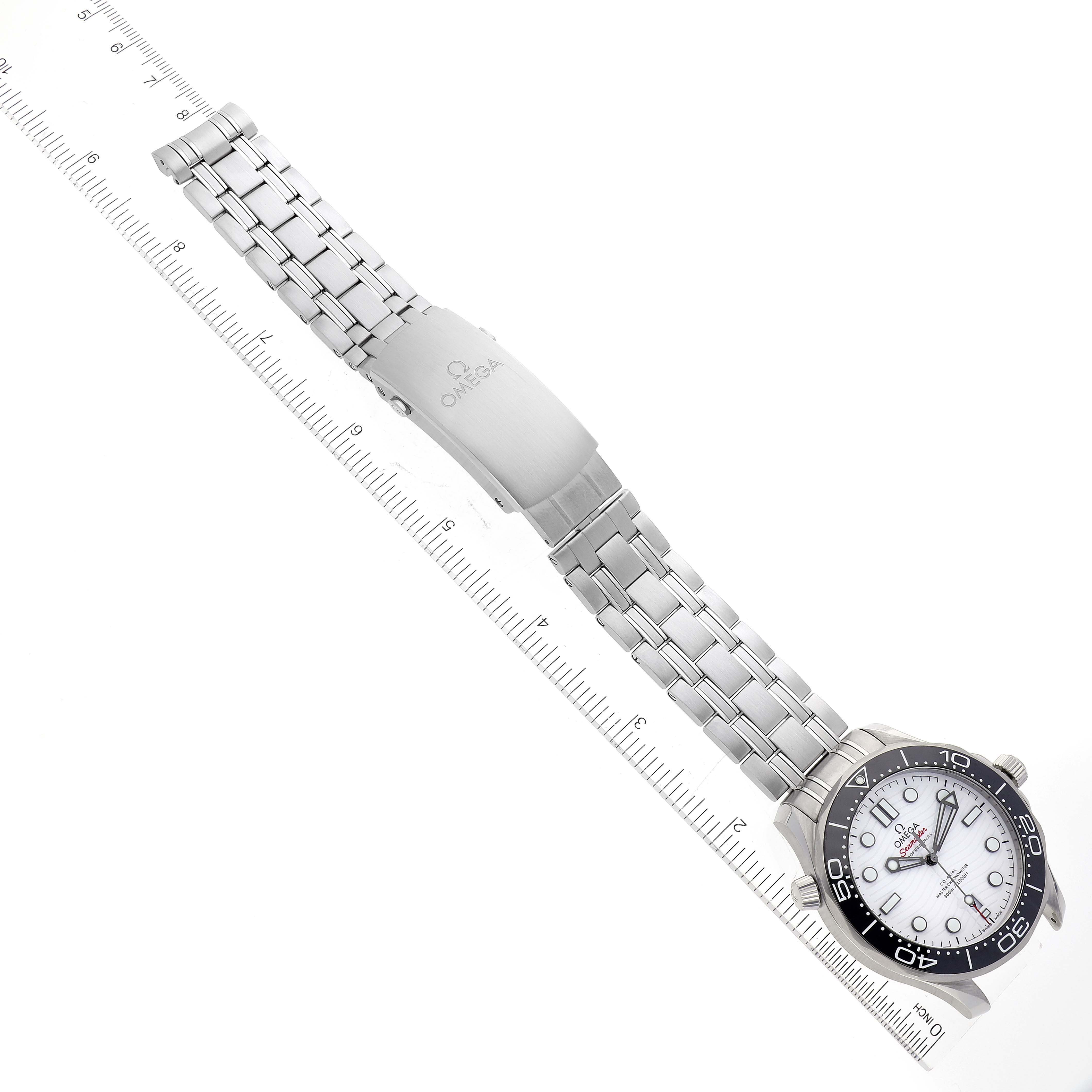 The image shows an Omega Seamaster 210.30.42.20.04.001 Men's Stainless Steel White Dial 210.30.42.20.04.001 Men's Stainless Steel White Dial watch laid flat alongside a ruler, displaying the watch face, bezel, and metal bracelet with a clasp.