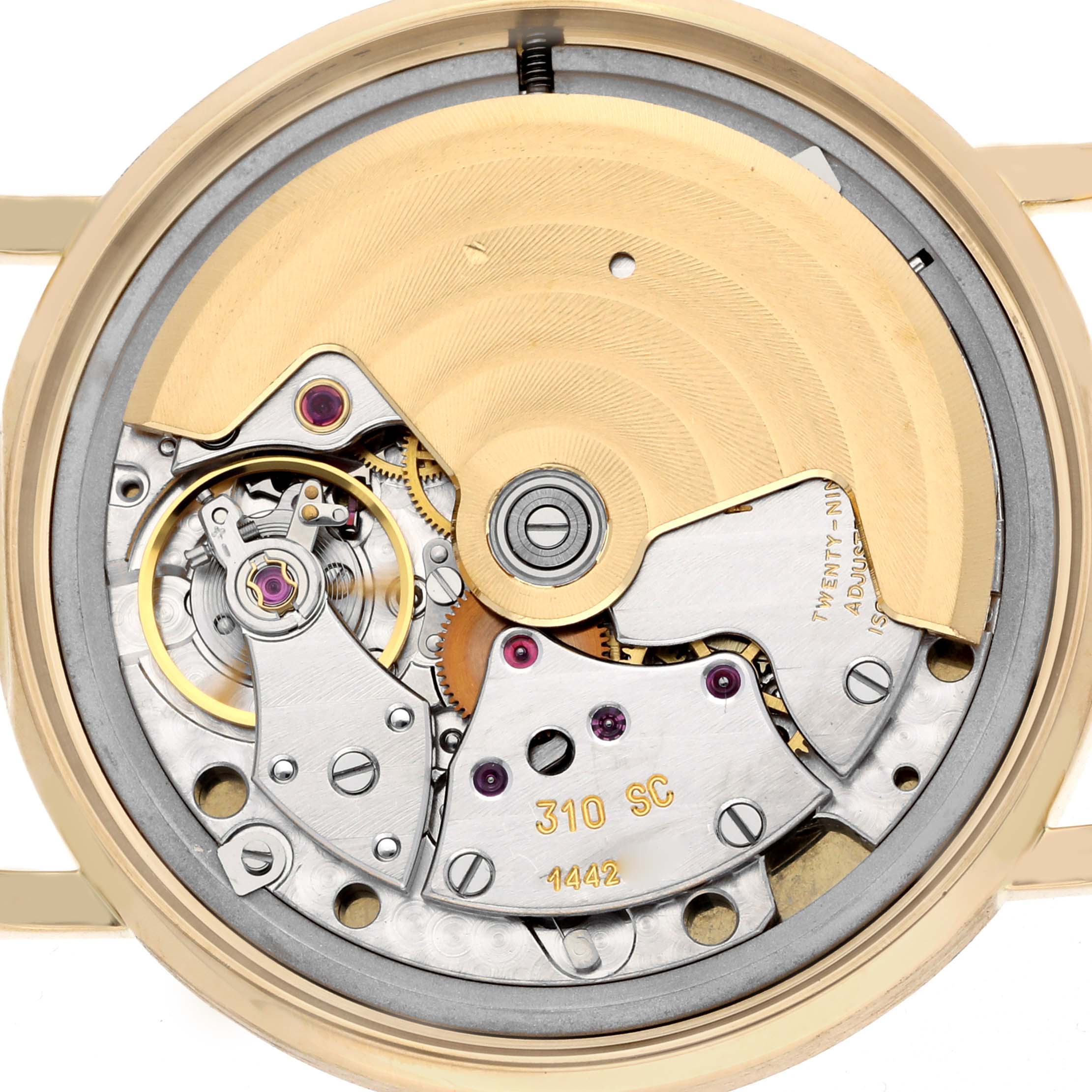 The image shows the movement of a Patek Philippe Calatrava 3802J Men
s Yellow Gold White Dial from a rear angle, featuring gears, rotors, and engravings.