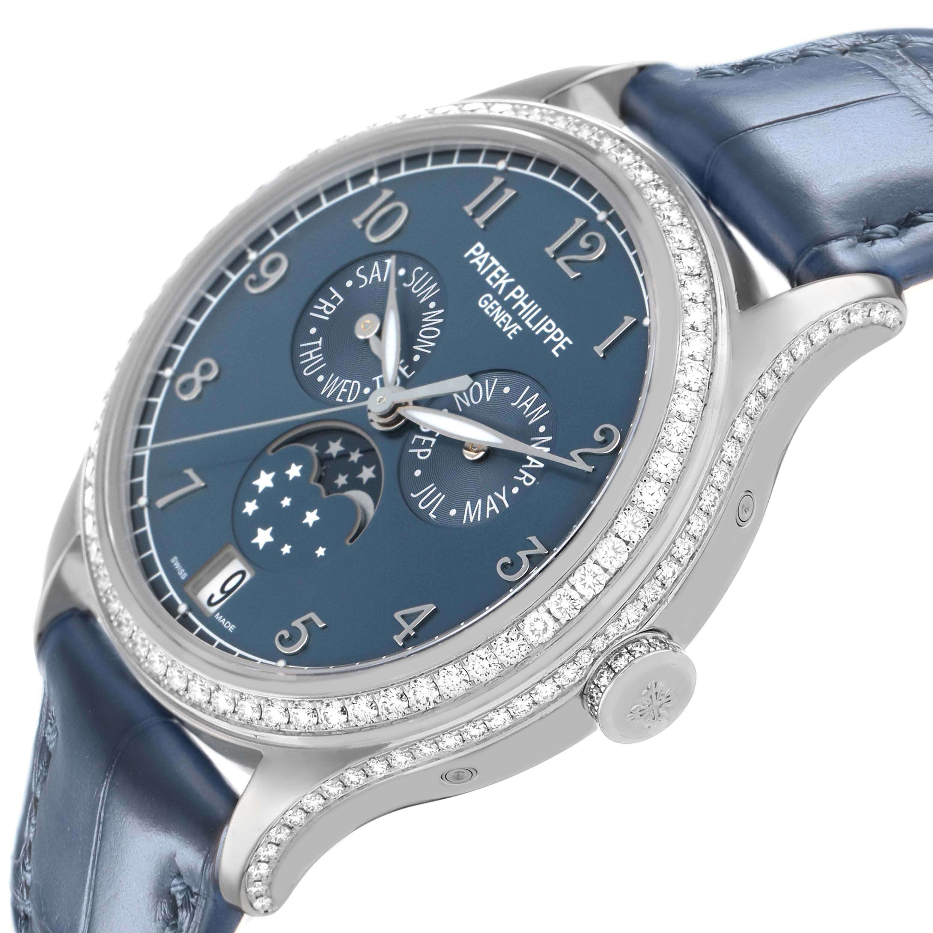 The Patek Philippe Complications 4947G-001 Mens White Gold Blue Dial watch is shown at a slight angle, displaying its blue dial, diamond-set bezel, and side profile.