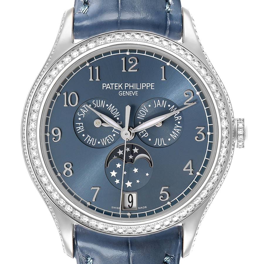 The Patek Philippe Complications 4947G-001 Men's White Gold Blue Dial watch is shown from a front angle, displaying its dial with day, month, and moon phase indicators.