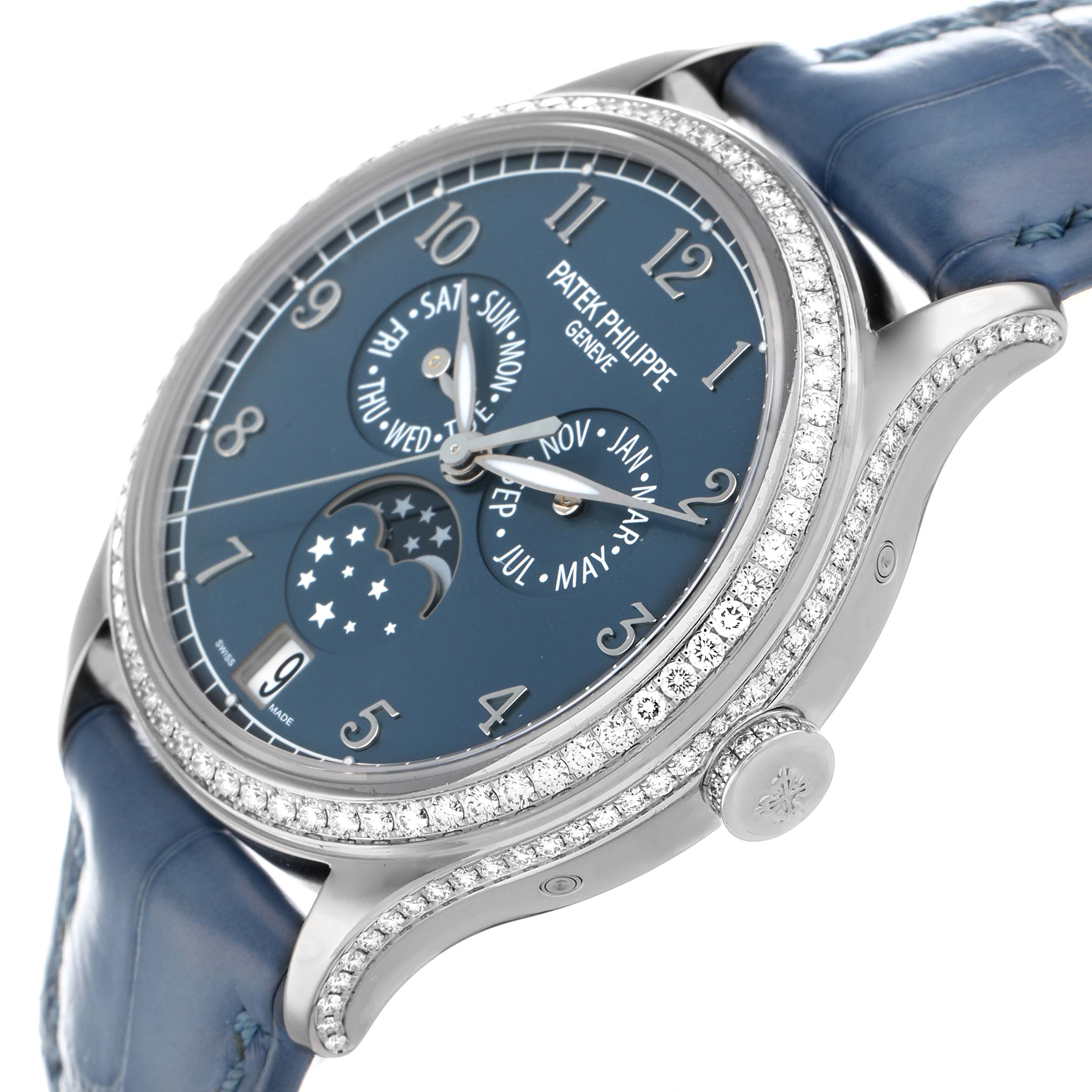 The Patek Philippe Complications 4947G-001 Men
s White Gold Blue Dial model is shown from a three-quarter angle highlighting the blue dial, moon phase, and diamond bezel.
