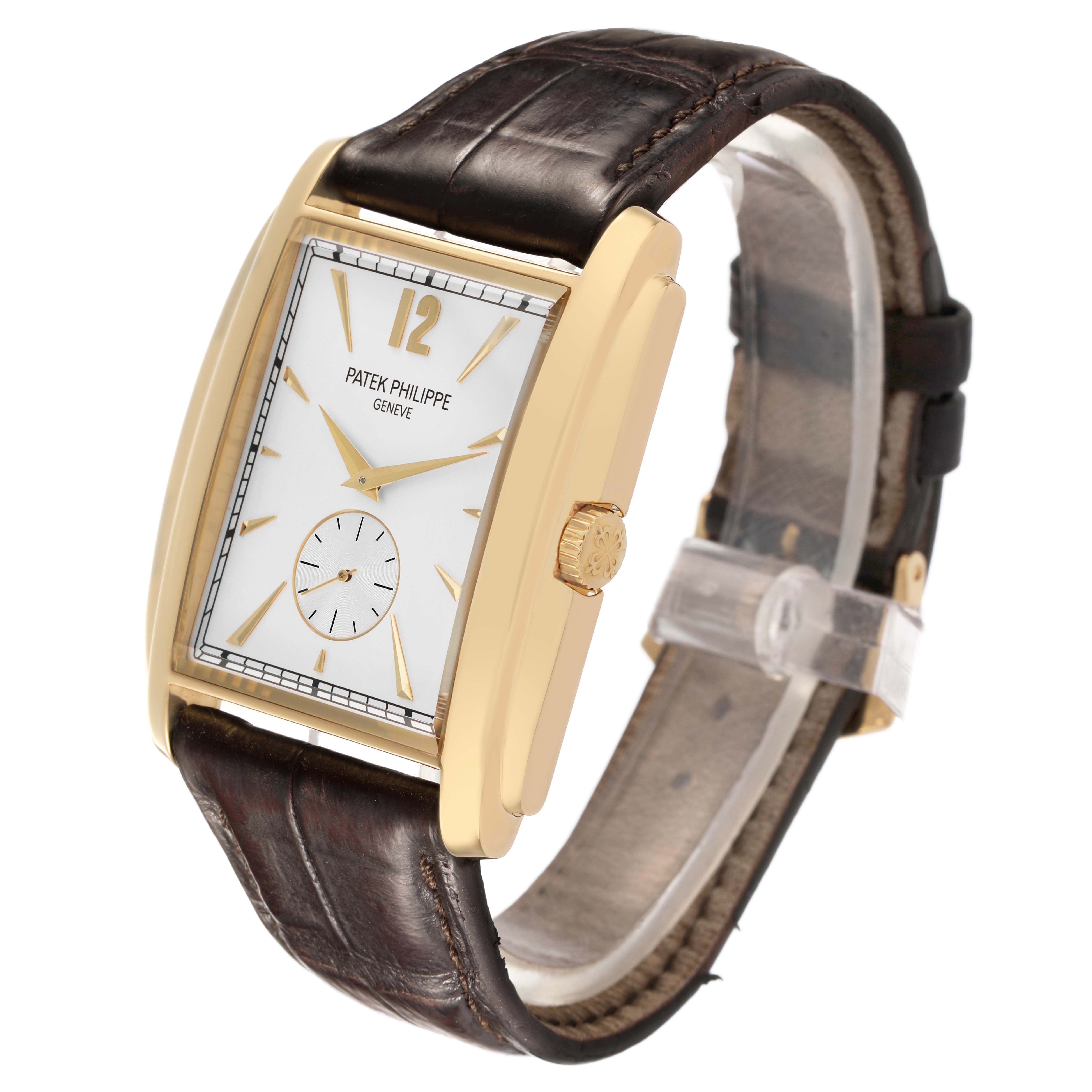The Patek Philippe Gondolo 5124J-001 Men's Yellow Gold Silver Dial watch is shown at a three-quarter angle, highlighting its gold case, white dial, brown strap, and crown.