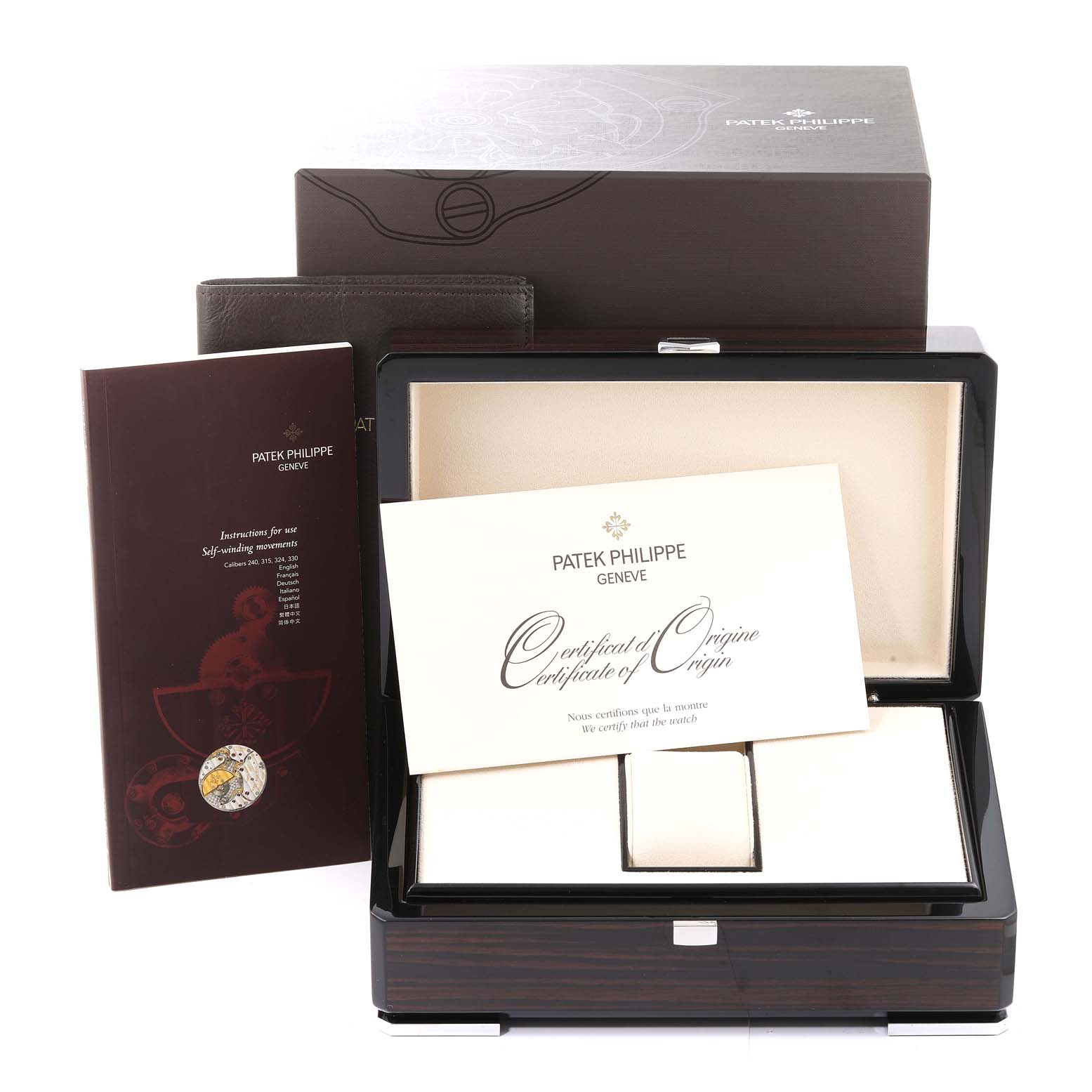 The image shows the packaging, certificate, and instruction manual of a Nautilus model by Patek Philippe.