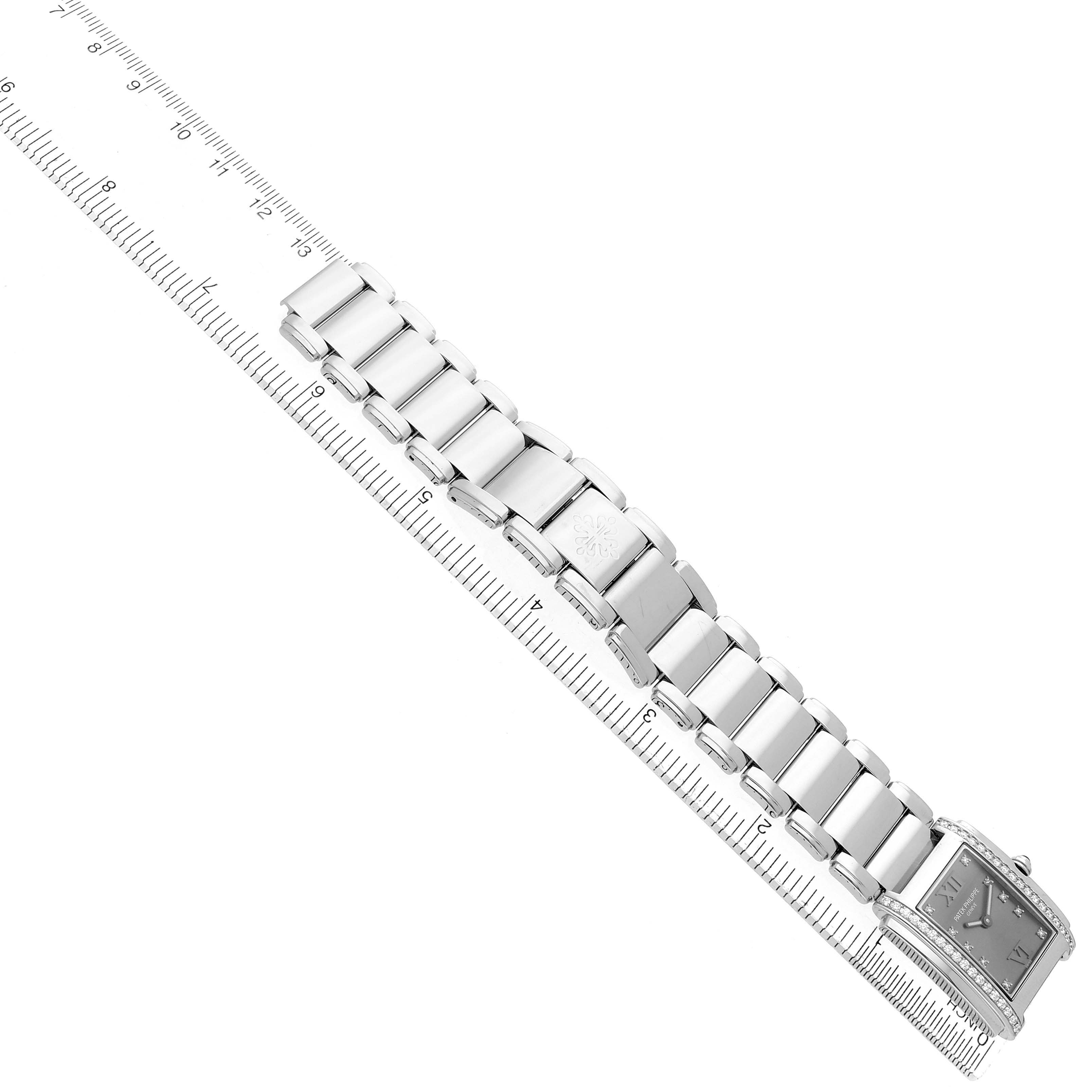 The Patek Philippe Twenty-4 4910/10A-010 Women's Stainless Steel Silver Dial watch is shown from a top angle, displaying the bracelet and part of the face, beside a ruler.