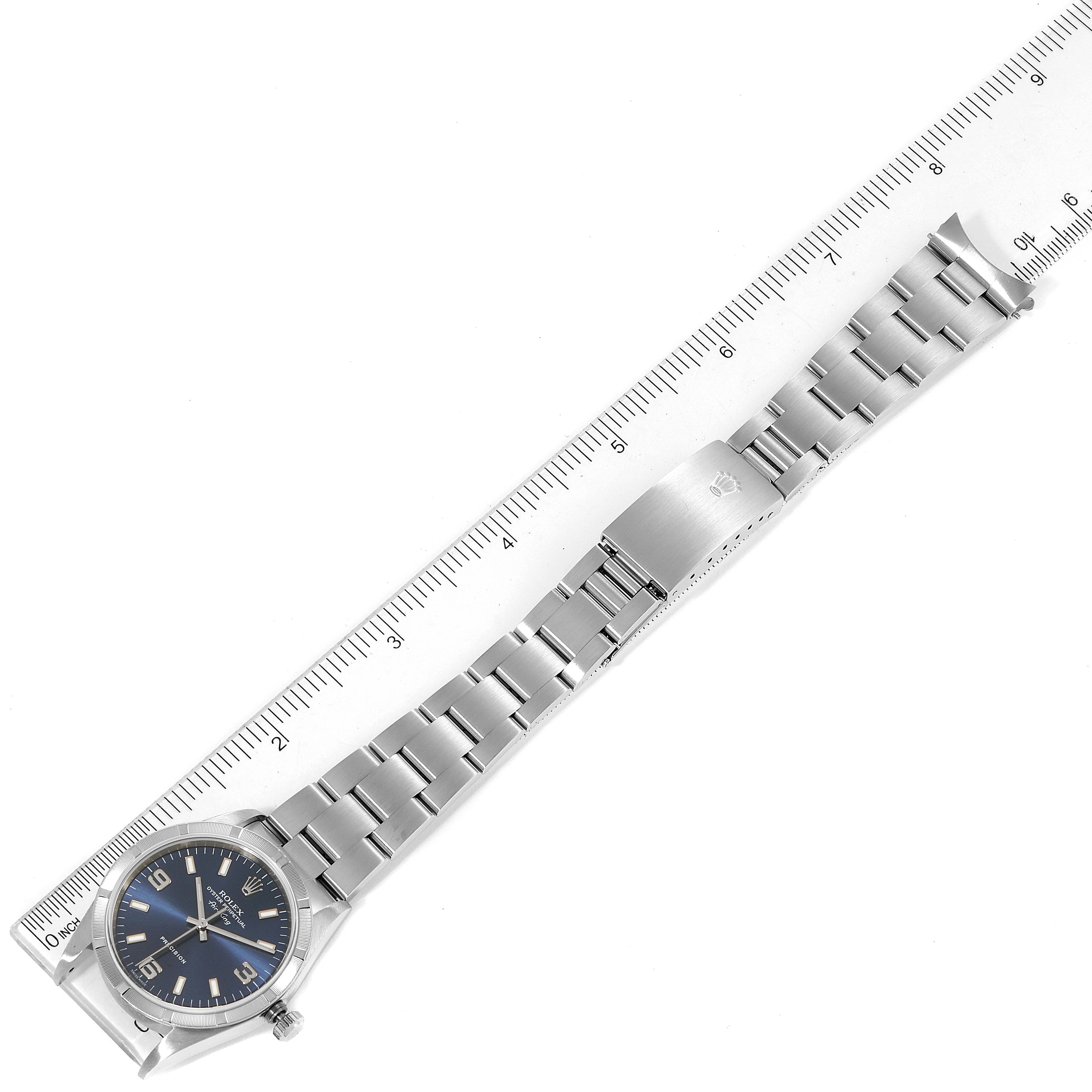 This image shows a Rolex Air-King 14010 Men's Stainless Steel Blue Dial 14010 Men's Stainless Steel Blue Dial watch from an overhead view, displaying the entire watch with its bracelet next to a ruler.