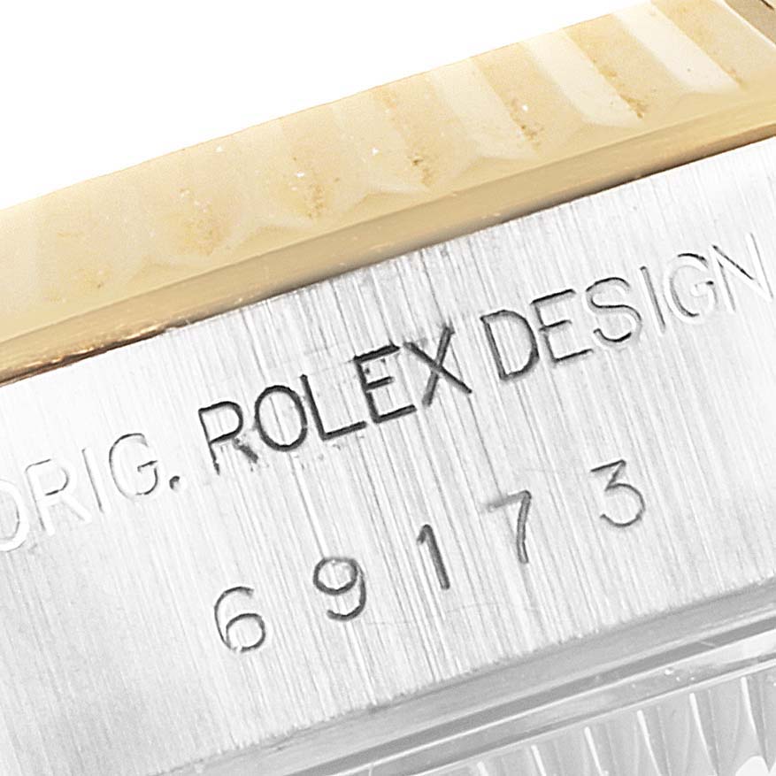 The image shows a close-up of a serial number and "ROLEX DESIGN" engraving on the case of a Rolex Datejust 69173 Women's Steel and Gold (two tone) Champagne Dial 69173 Women's Steel and Gold (two tone) Champagne Dial watch.
