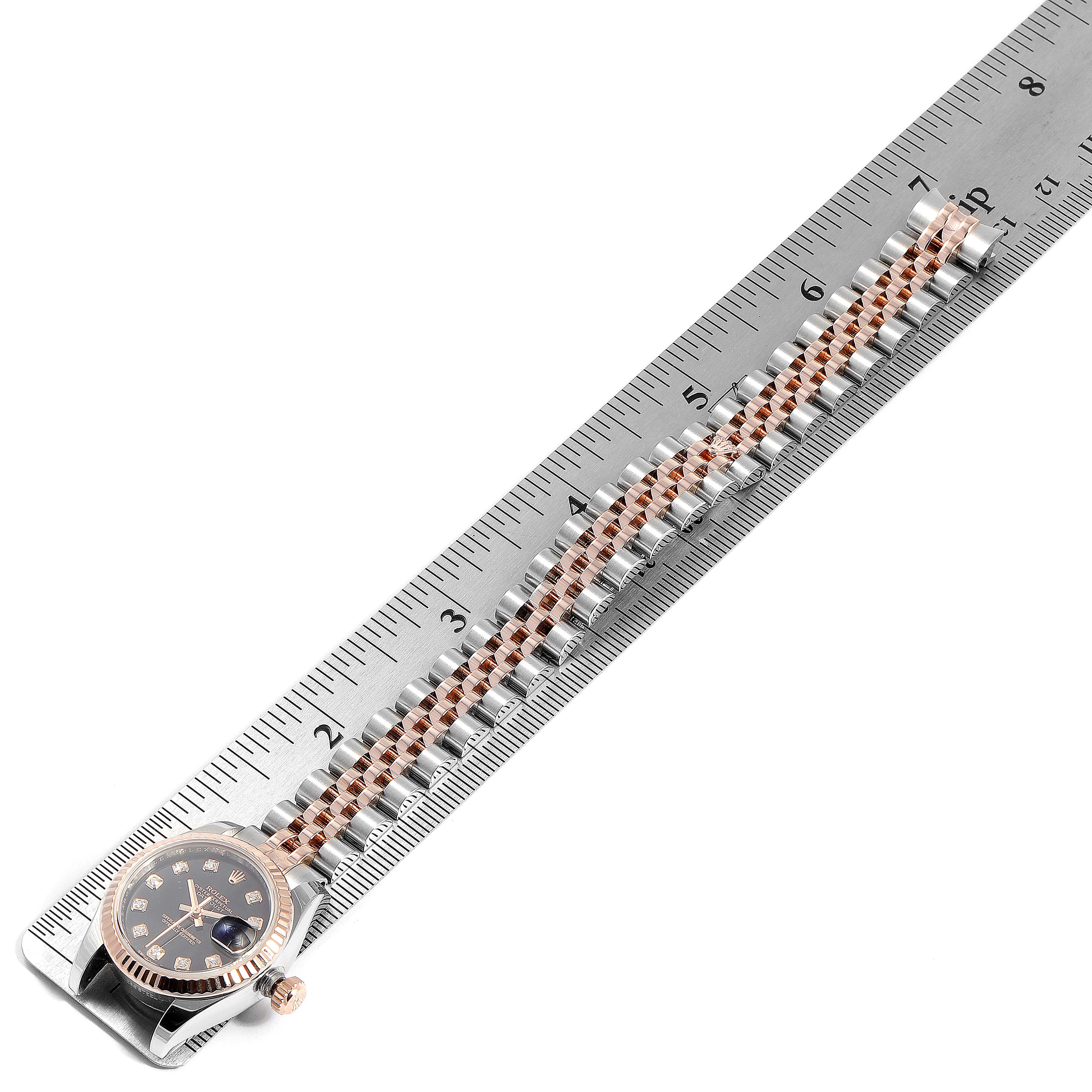 The image shows a Rolex Datejust 179171 Women's Rose Gold Black Dial 179171 Women's Rose Gold Black Dial laid flat next to a ruler, focusing on its dial, crown, and bracelet.