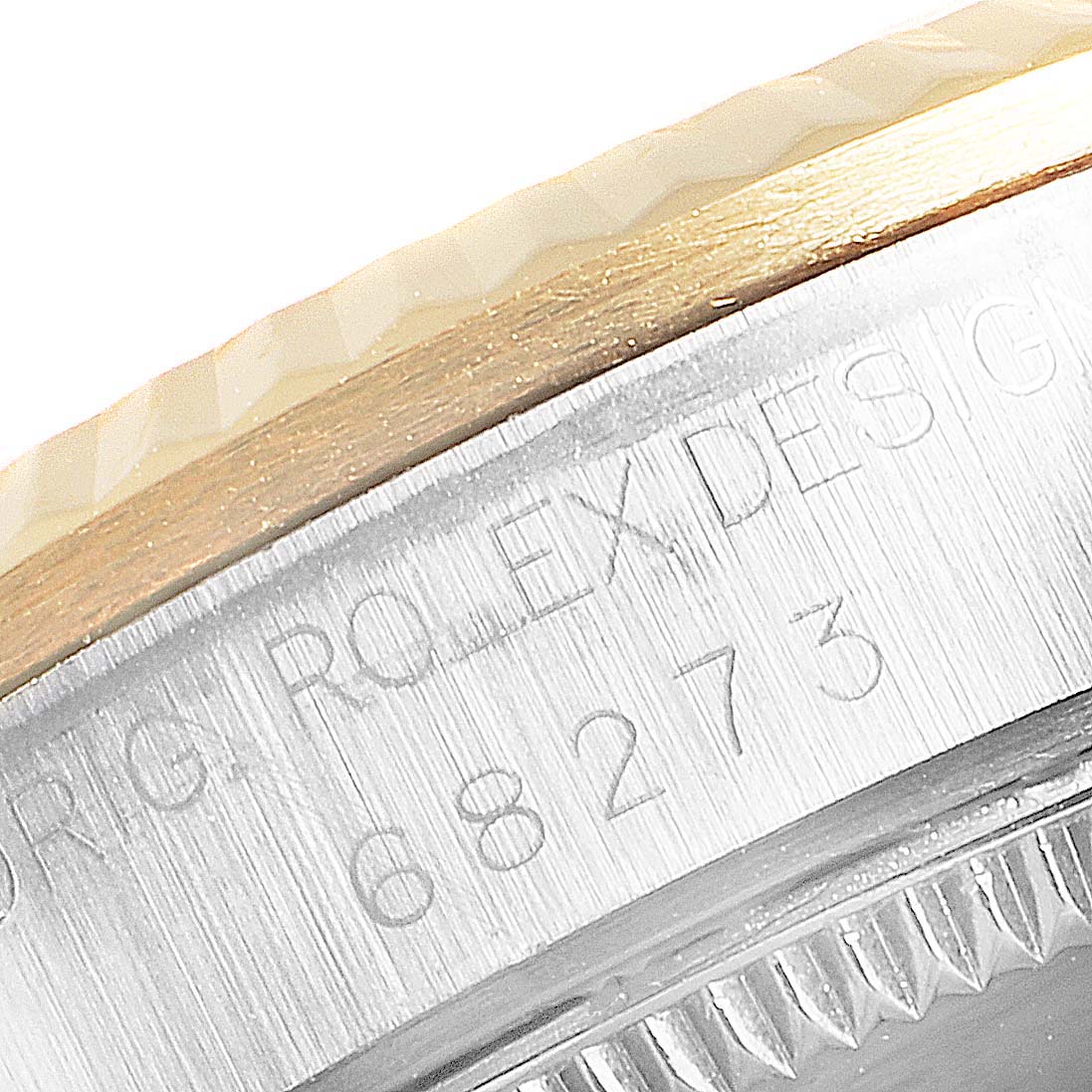 This close-up image of a Rolex Mid-Size 68273 Women
s Steel and Gold (two tone) Champagne Dial 68273 Women
s Steel and Gold (two tone) Champagne Dial model shows a partial view of the watch case with engraved text and part of the bezel.