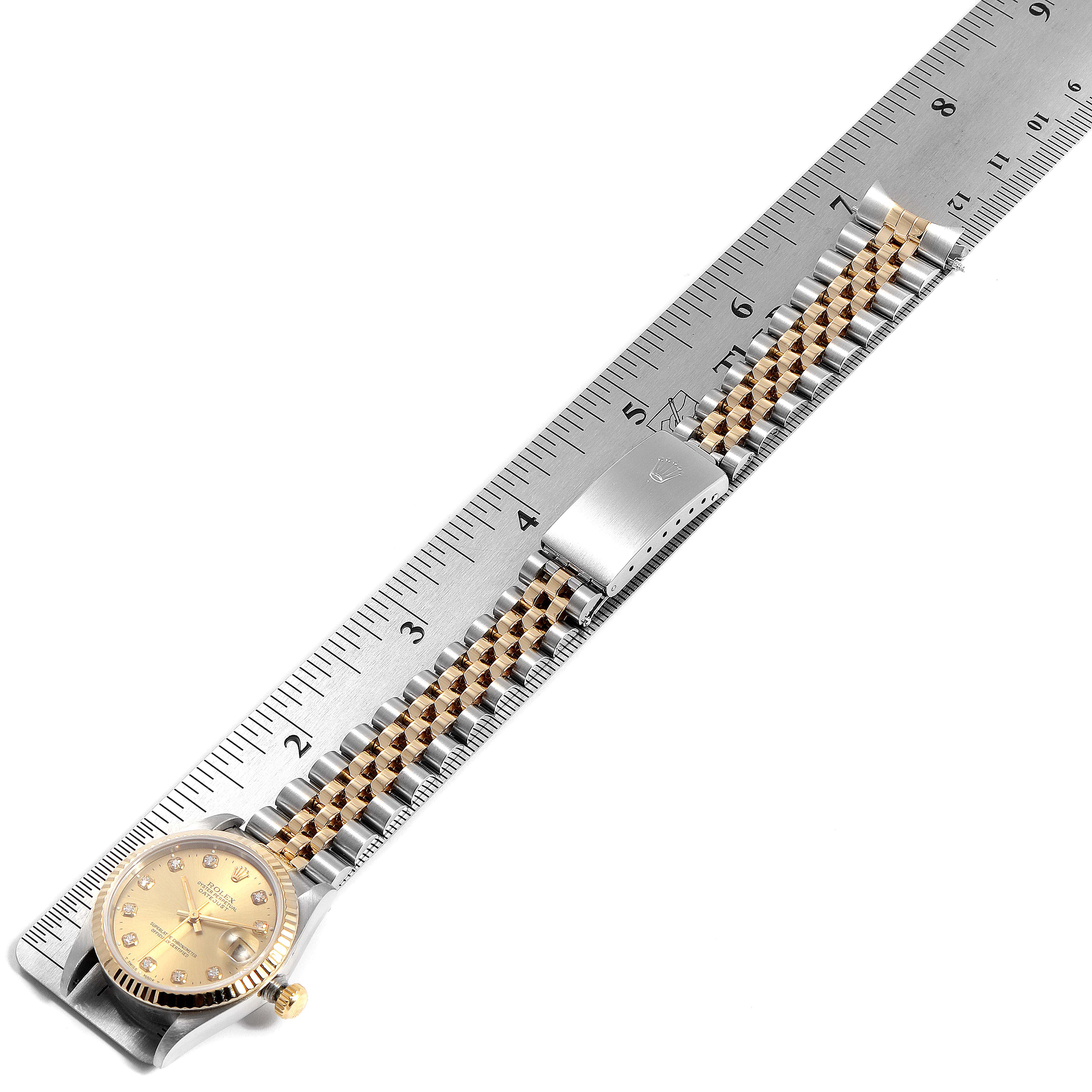 The image shows the entire Rolex Mid-Size 68273 Women
s Steel and Gold (two tone) Champagne Dial 68273 Women
s Steel and Gold (two tone) Champagne Dial watch, including its face, bezel, crown, and metal bracelet, aligned next to a ruler.
