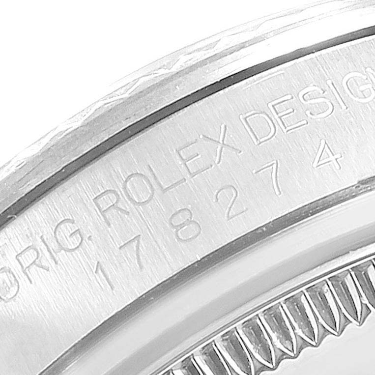 This close-up image shows the engraved side of a Mid-Size Rolex watch, focusing on the serial number and branding.