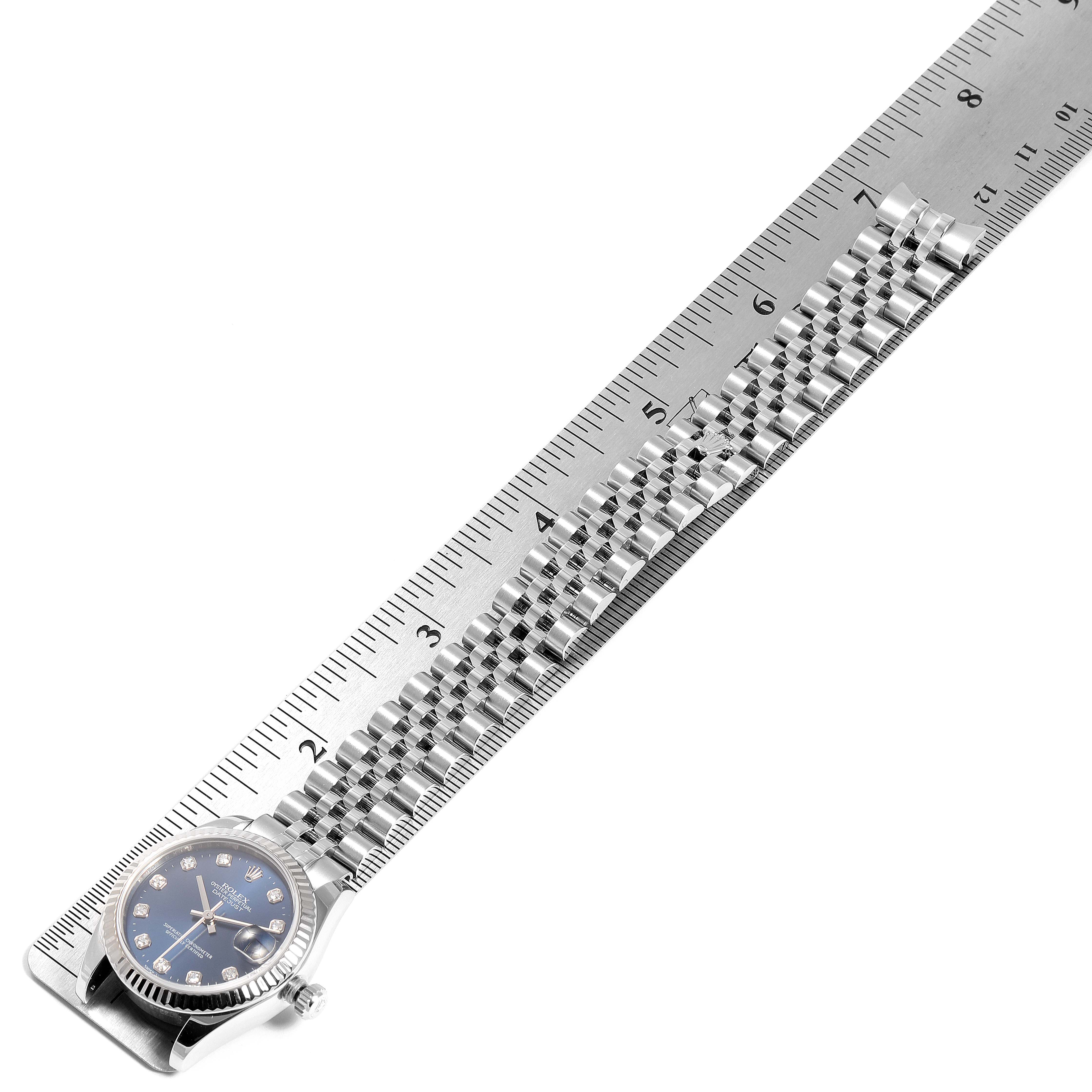 The image shows a side angle of a Mid-Size Rolex watch with a metal bracelet laid next to a ruler.