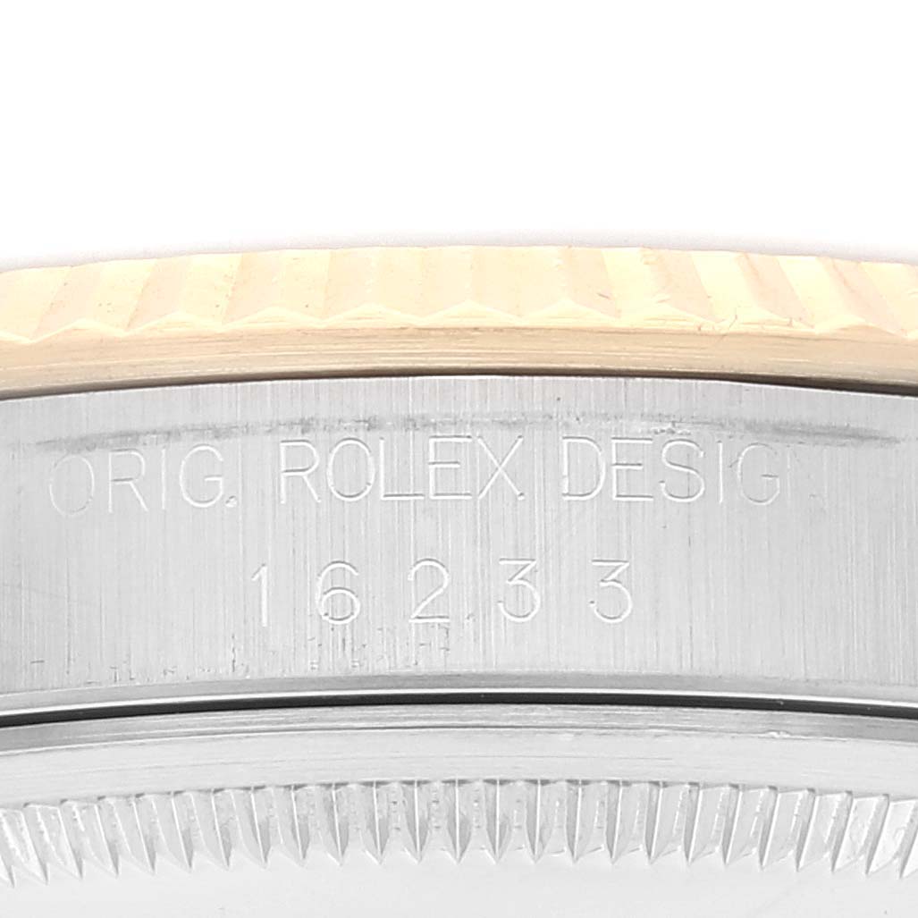 The image shows a close-up of the side of a Rolex Datejust 16233 Men's Steel and Gold (two tone) Blue Dial 16233 Men's Steel and Gold (two tone) Blue Dial watch, revealing the "ORIG. ROLEX DESIGN 16233" engraving.