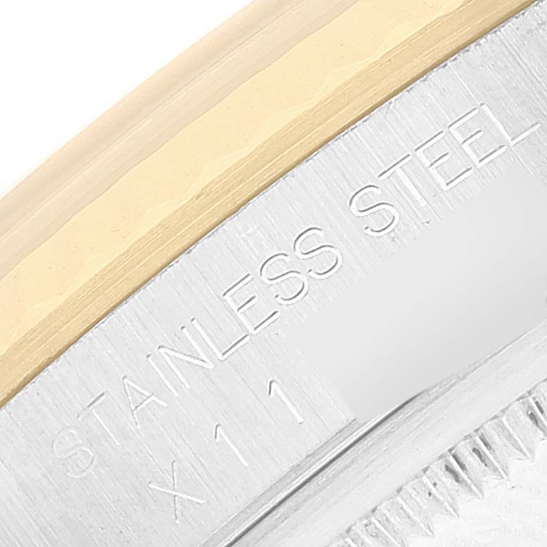 Close-up shot of a Rolex Datejust 16233 Men's Steel and Gold (two tone) Champagne Dial 16233 Men's Steel and Gold (two tone) Champagne Dial watch showing part of the bezel, case, and engravings on the stainless steel.