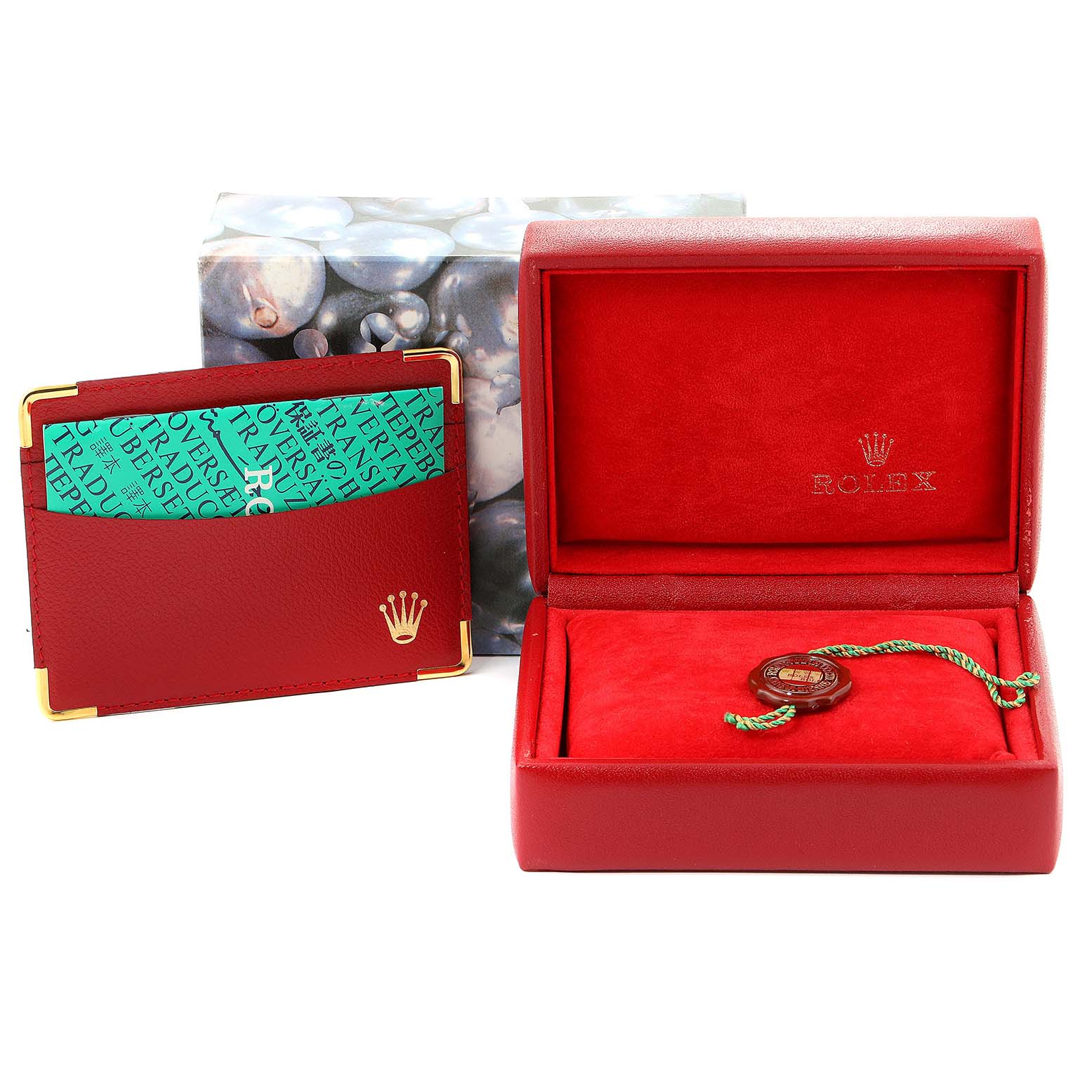 The image shows a red Rolex Datejust 79173 Women's Steel and Gold (two tone) Blue Dial 79173 Women's Steel and Gold (two tone) Blue Dial box, a green and gold Rolex card holder, and a tag, all from a frontal angle.