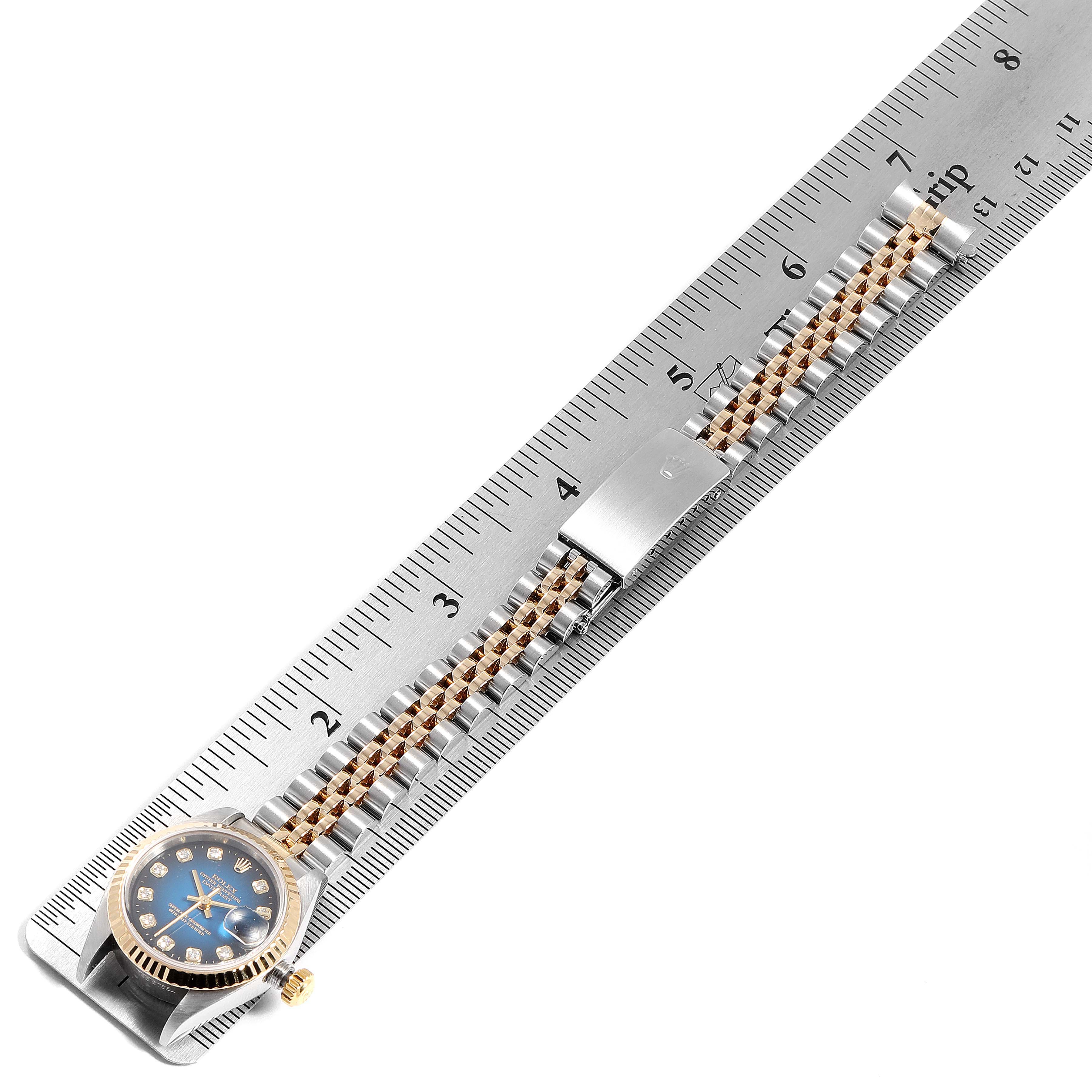 The image shows a Rolex Datejust 79173 Women's Steel and Gold (two tone) Blue Dial 79173 Women's Steel and Gold (two tone) Blue Dial watch with its face and band laid flat against a measuring ruler.