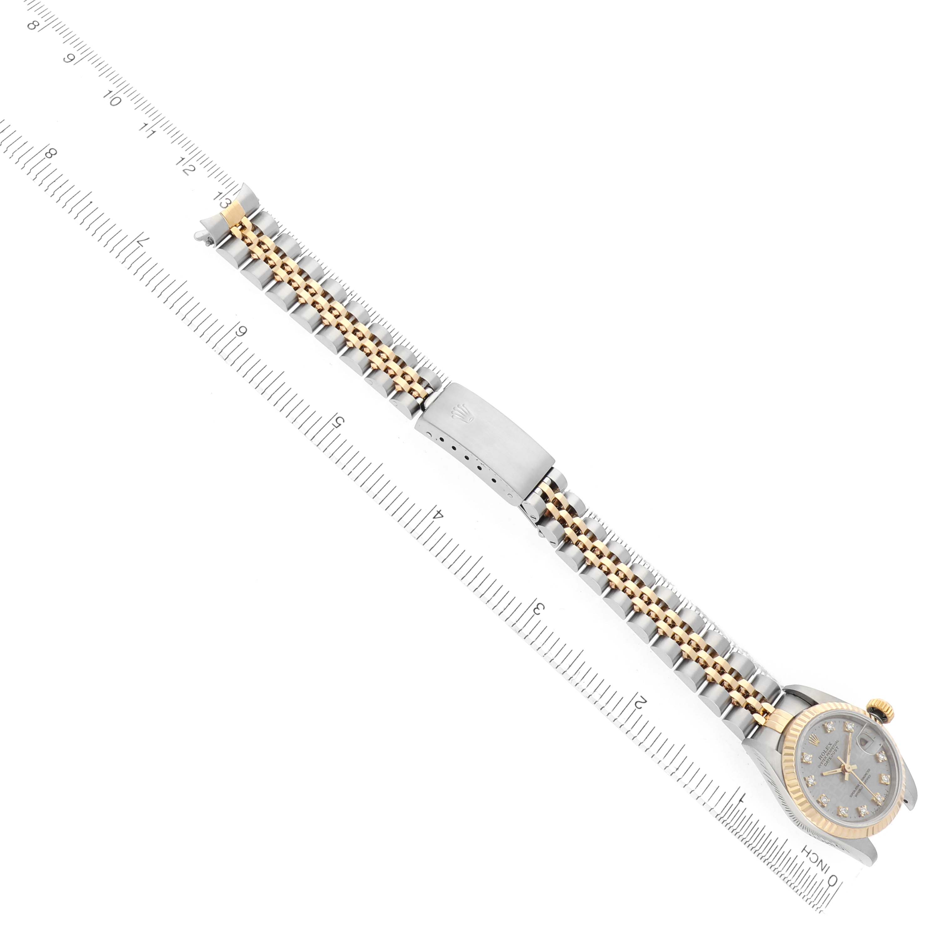 The Rolex Datejust 69173 Women's Steel and Gold (two tone) Champagne Dial watch is shown from a top-down angle, displaying the bracelet and clasp fully extended next to a ruler.