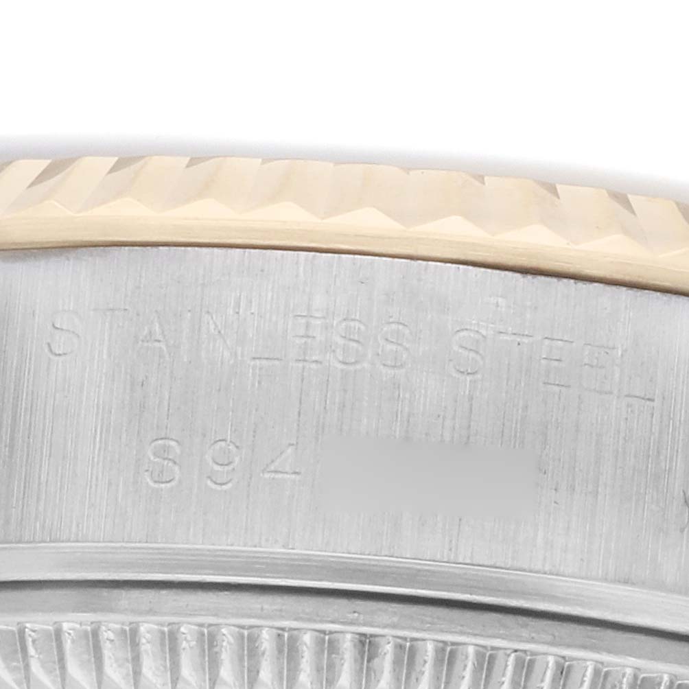 The image shows a close-up of the side of a Rolex Datejust 69173 Women's Steel and Gold (two tone) Champagne Dial, focusing on the fluted bezel and engraved edge.