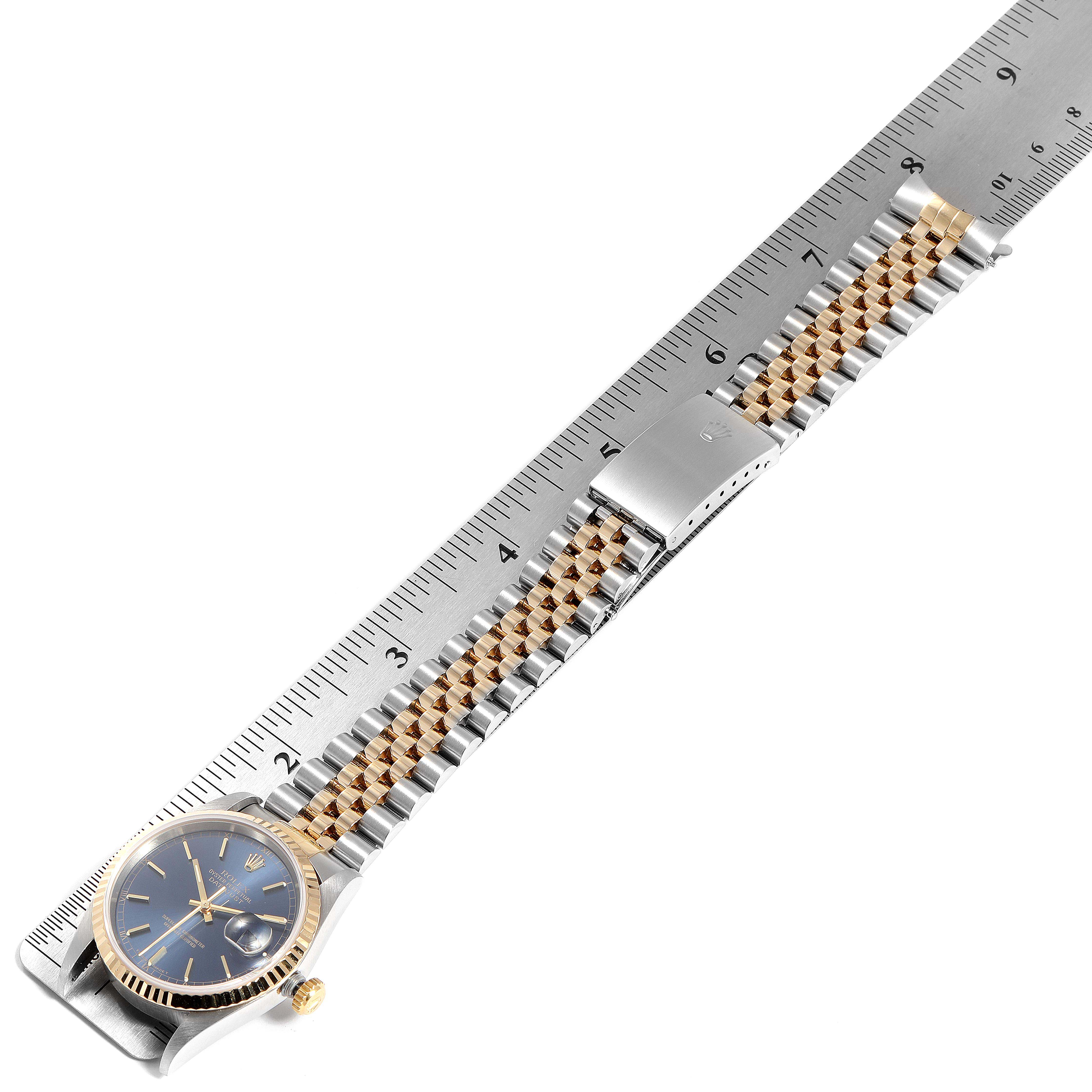 This image shows the Rolex Datejust 16233 Men's Steel and Gold (two tone) Blue Dial 16233 Men's Steel and Gold (two tone) Blue Dial watch laid flat, measuring the bracelet length with a ruler.