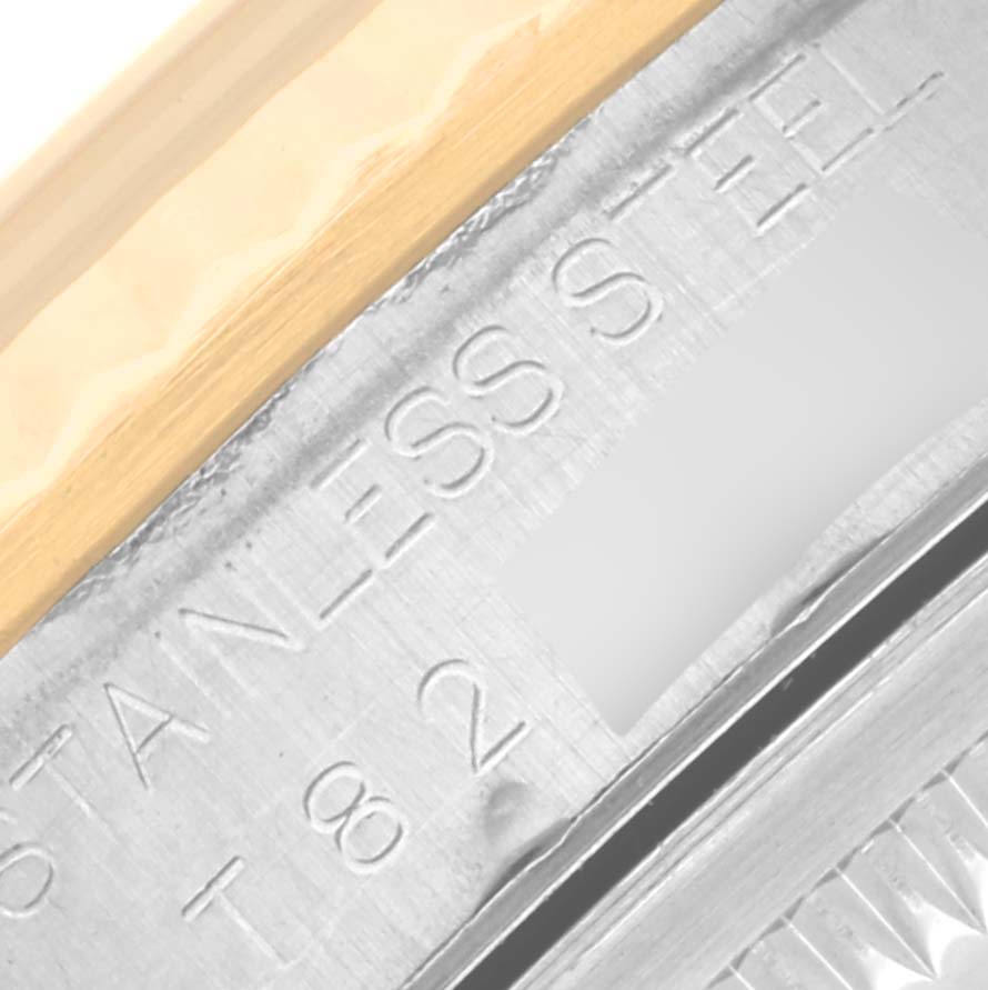 The image shows a close-up of the side of a Rolex Datejust 16233 Men's Steel and Gold (two tone) Champagne Dial 16233 Men's Steel and Gold (two tone) Champagne Dial watch featuring part of the bezel and text on the stainless steel case.