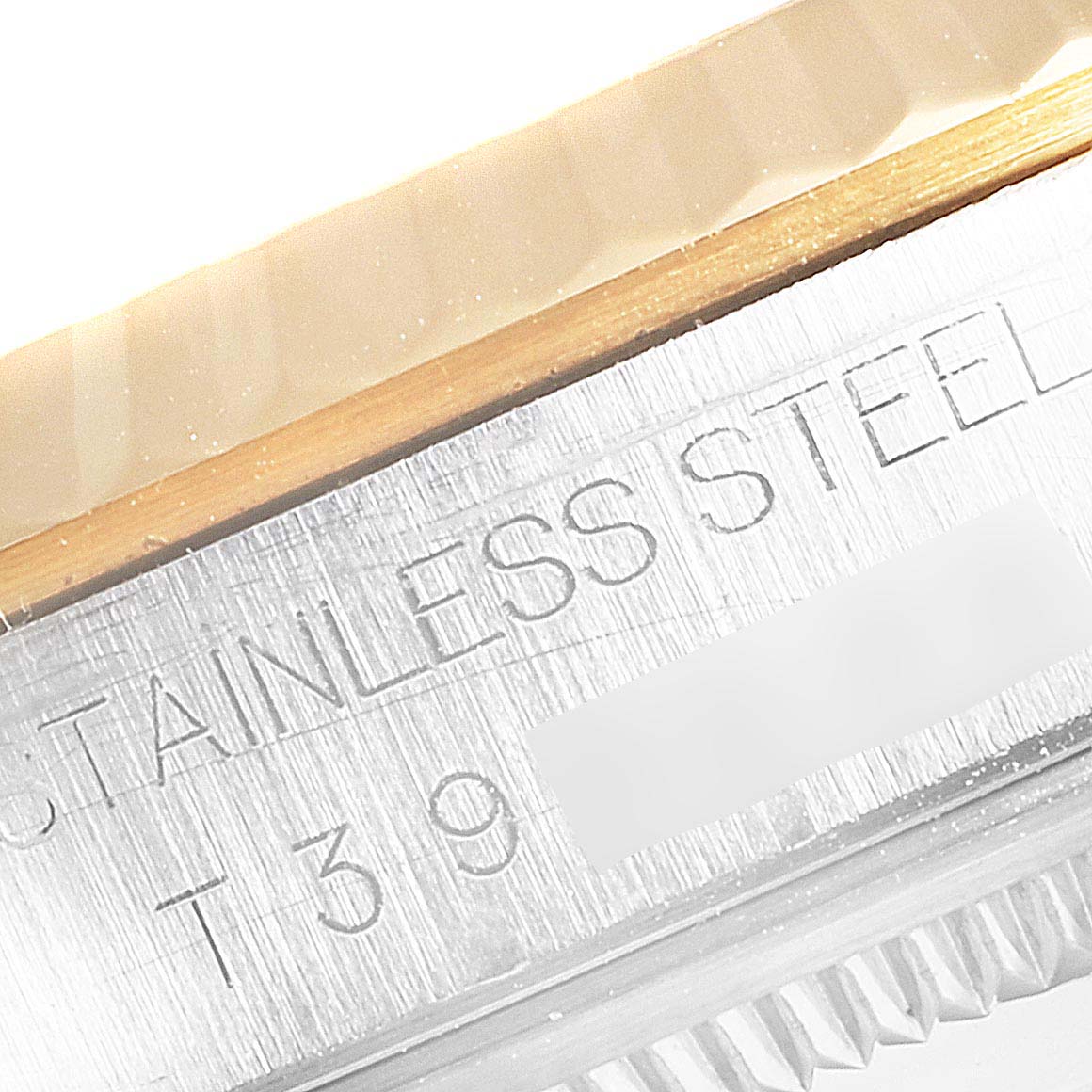 This close-up image of a Rolex Datejust 16233 Men's Steel and Gold (two tone) Blue Dial 16233 Men's Steel and Gold (two tone) Blue Dial watch shows part of the stainless steel case and the fluted bezel.