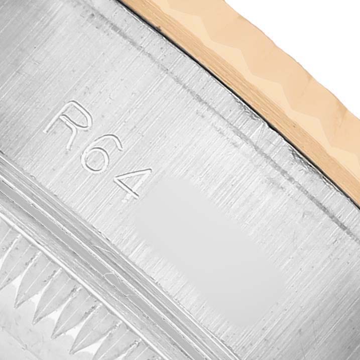 The image shows a close-up of a Rolex Datejust 69173 Women's Steel and Gold (two tone) Silver Dial's bezel and case side, highlighting engravings and the fluted bezel edge.