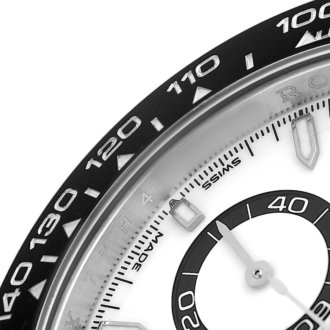 The image shows a close-up of a Rolex Daytona 126500 Men's Stainless Steel White Dial watch, focusing on the tachymetric bezel and part of the dial.