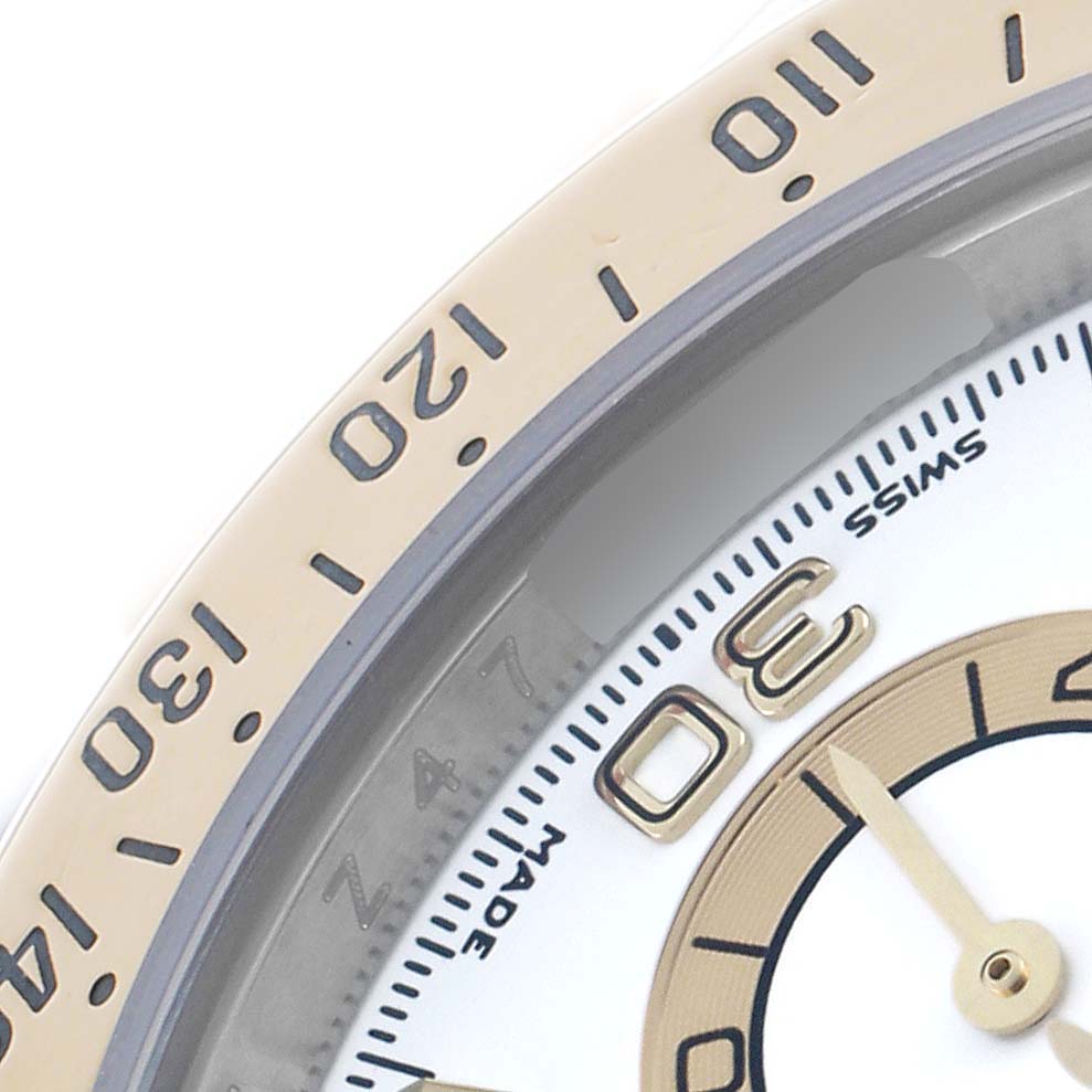 The image shows a close-up of the Rolex Daytona 116523 Men's Steel and Gold (two tone) White Dial watch bezel and part of the dial and hands, highlighting the tachymeter scale.