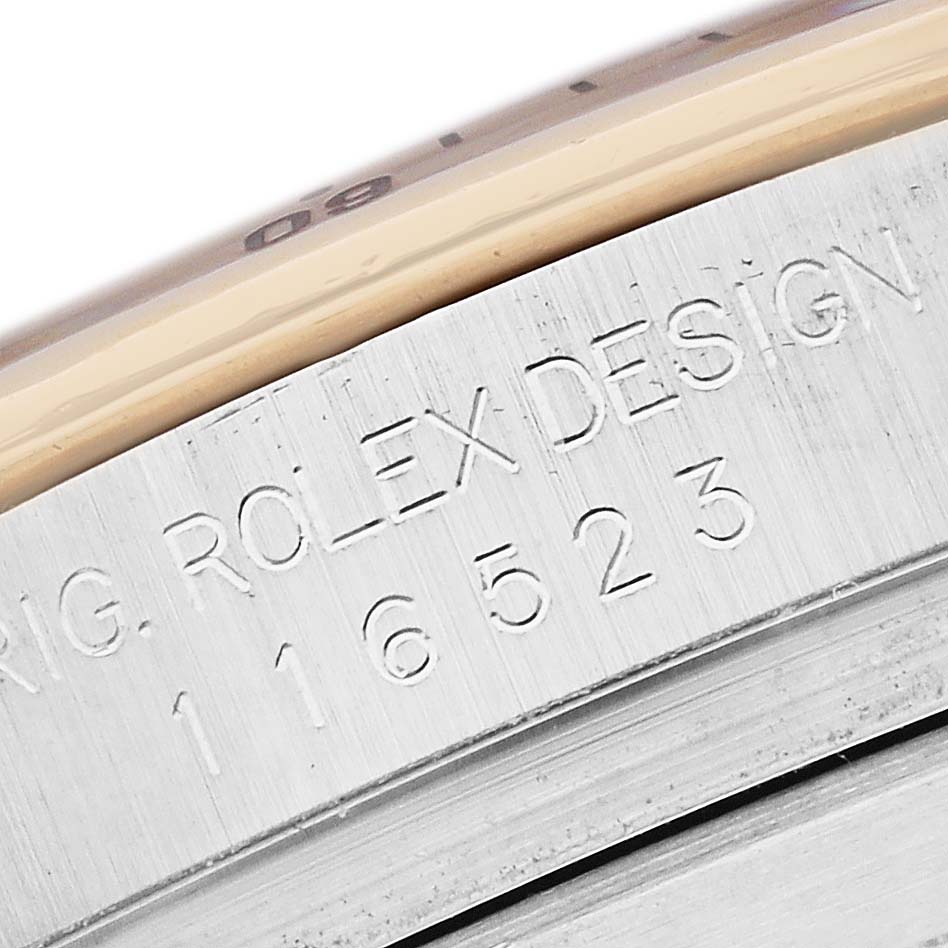 The image shows a close-up of the side of the Rolex Daytona 116523 Men's Steel and Gold (two tone) White Dial, focusing on the engraved design and model number.
