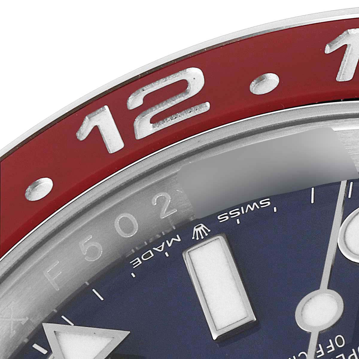 This close-up of the Rolex GMT-Master 126719 Men's White Gold Blue Dial 126719 Men's White Gold Blue Dial shows the bezel with a '12' marker and part of the dial with the 'Swiss Made' text.