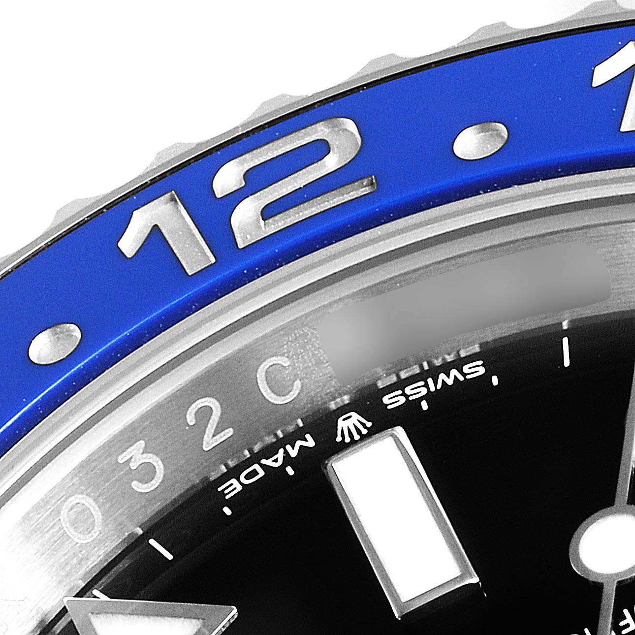 This image shows a close-up of the bezel and part of the dial of a Rolex GMT-Master 126710 Men
s Stainless Steel Black Dial 126710 Men
s Stainless Steel Black Dial watch, focusing on the "12" hour marker.