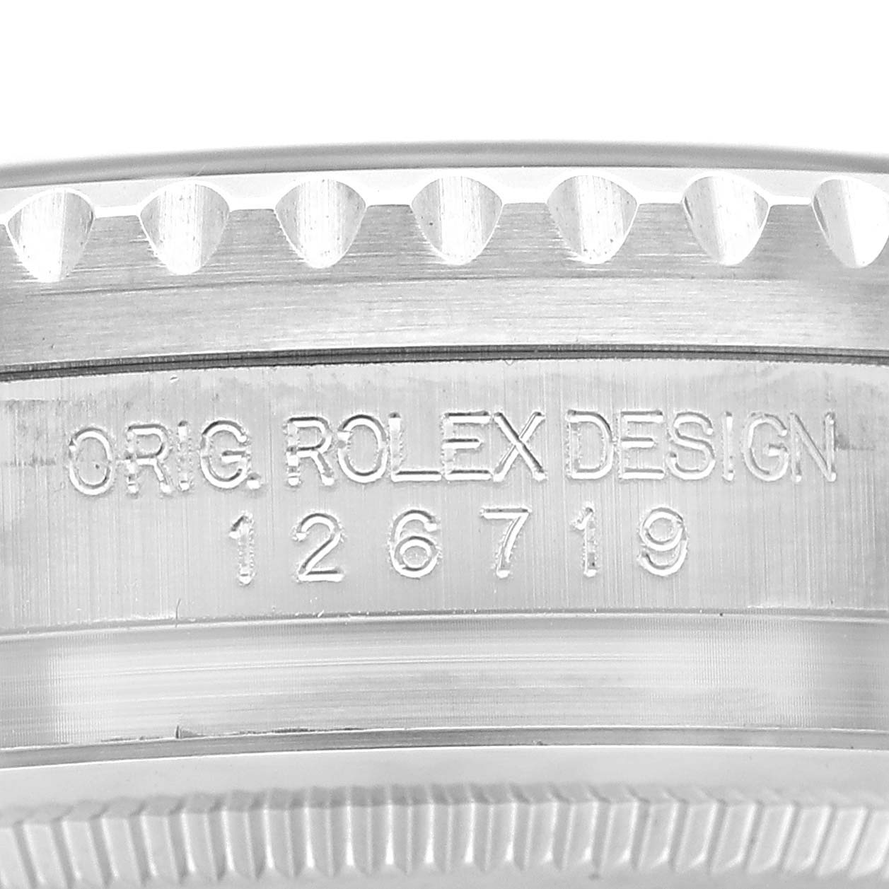The image shows a close-up of the engraved edge on a Rolex GMT-Master 126719BLRO Men's White Gold Silver Dial, displaying the model number "126719."