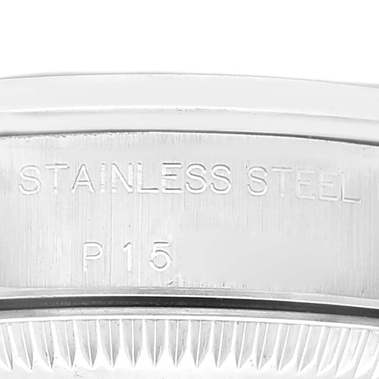 This image shows a close-up of the engraved stainless steel case of the Rolex Oyster Perpetual 76080 Women's Stainless Steel Blue Dial 76080 Women's Stainless Steel Blue Dial watch.